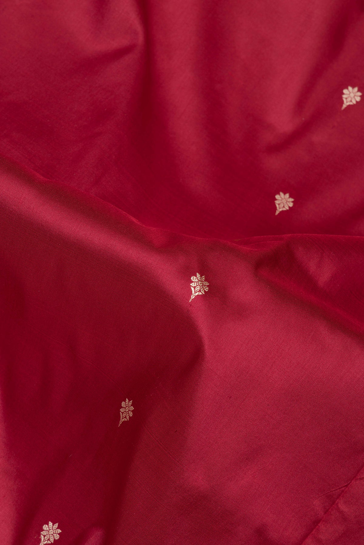 Close up of Maroon Banarasi Silk Saree with Thread Butta on the body and Thread Border.  displaying folds
