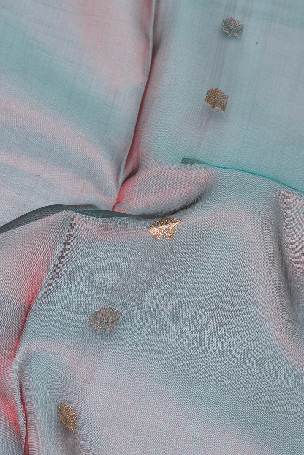 Close up of Green Dual Tone Organza Silk Saree with Zari Butta on the body and Zari Border.  displaying folds