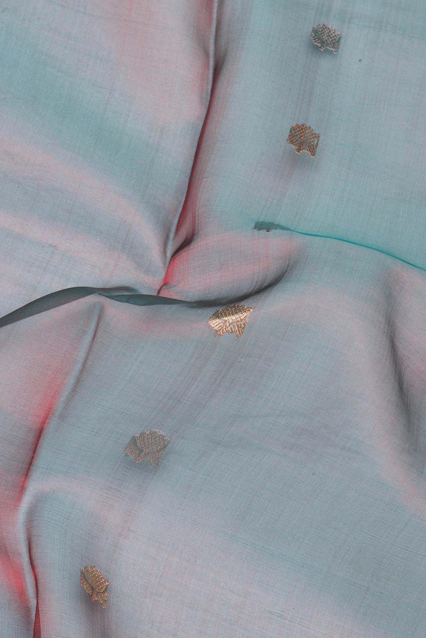 Close up of Green Dual Tone Organza Silk Saree with Zari Butta on the body and Zari Border.  displaying folds
