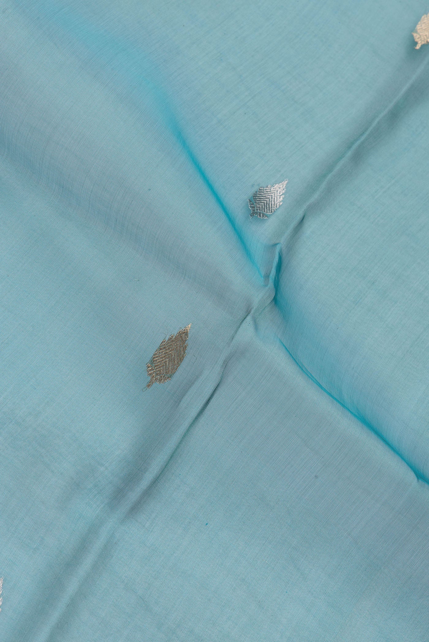 Close up of Sky Blue Dual Tone Organza Silk Saree with Zari Butta on the body and Zari Border.  displaying folds