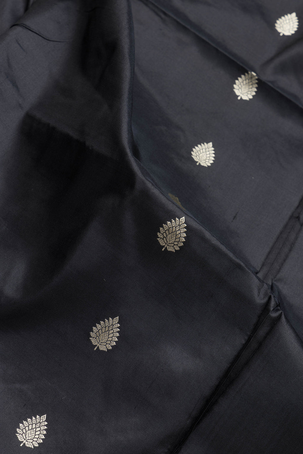 Close up of Black Dual Tone Banarasi Silk Saree with Thread Butta on the body and Thread Border.  displaying folds