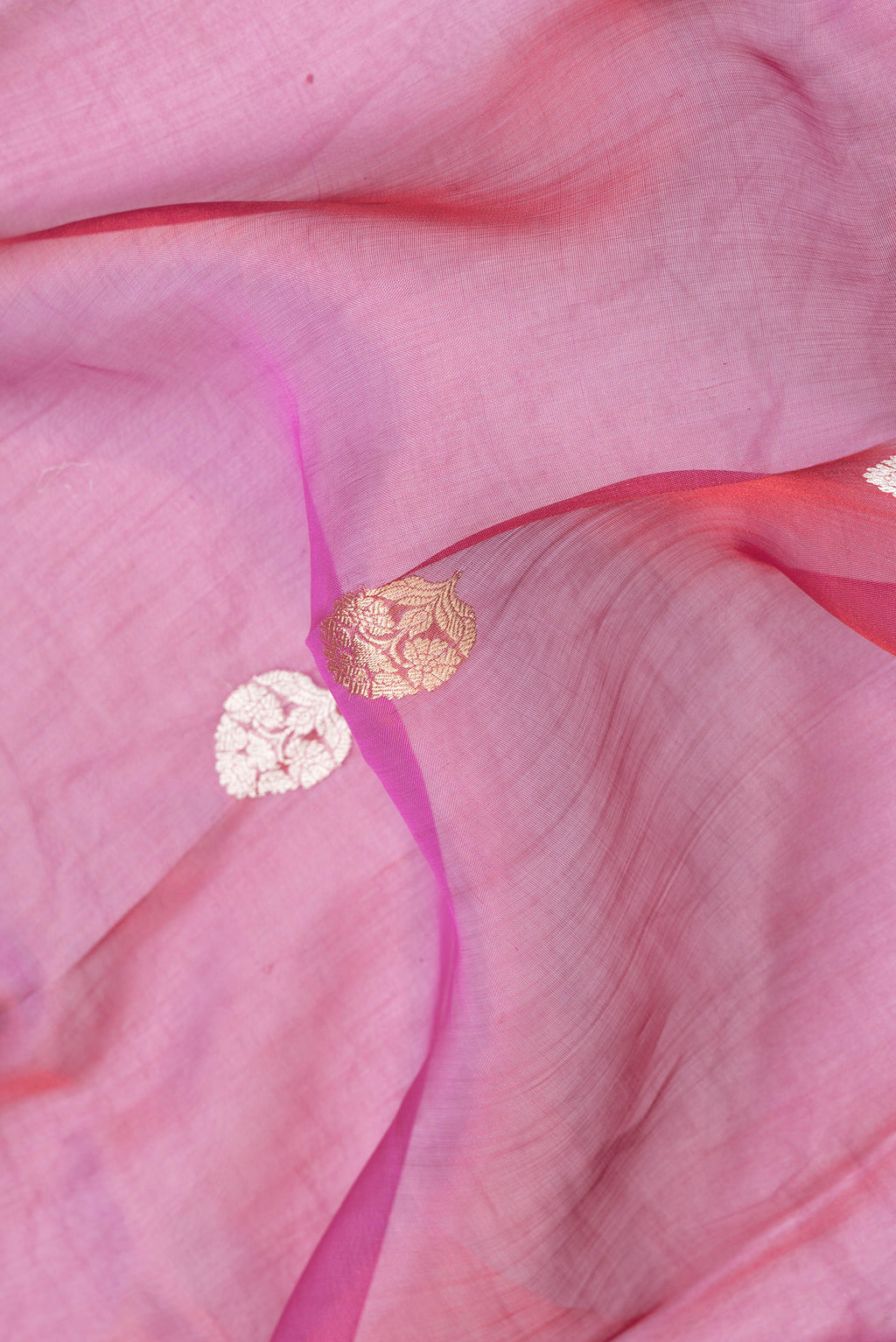 Close up of Dark Pink Dual Tone Organza Silk Saree with Zari Butta on the body and Fancy Border.  displaying folds