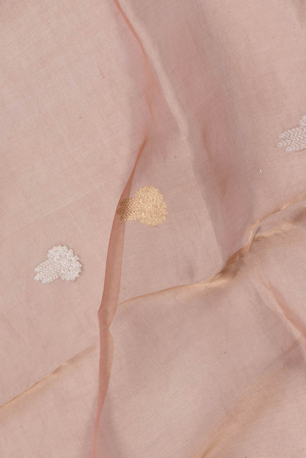 Close up of Rose Gold Dual Tone Organza Silk Saree with Zari Butta on the body and Zari Border.  displaying folds