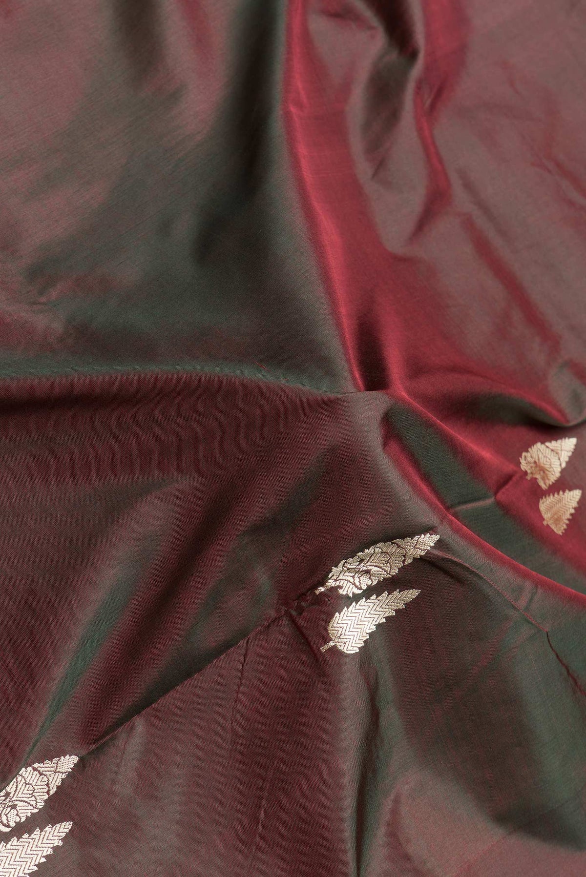 Close up of Green Dual Tone Banarasi Silk Saree with Thread Butta on the body and Thread Border.  displaying folds