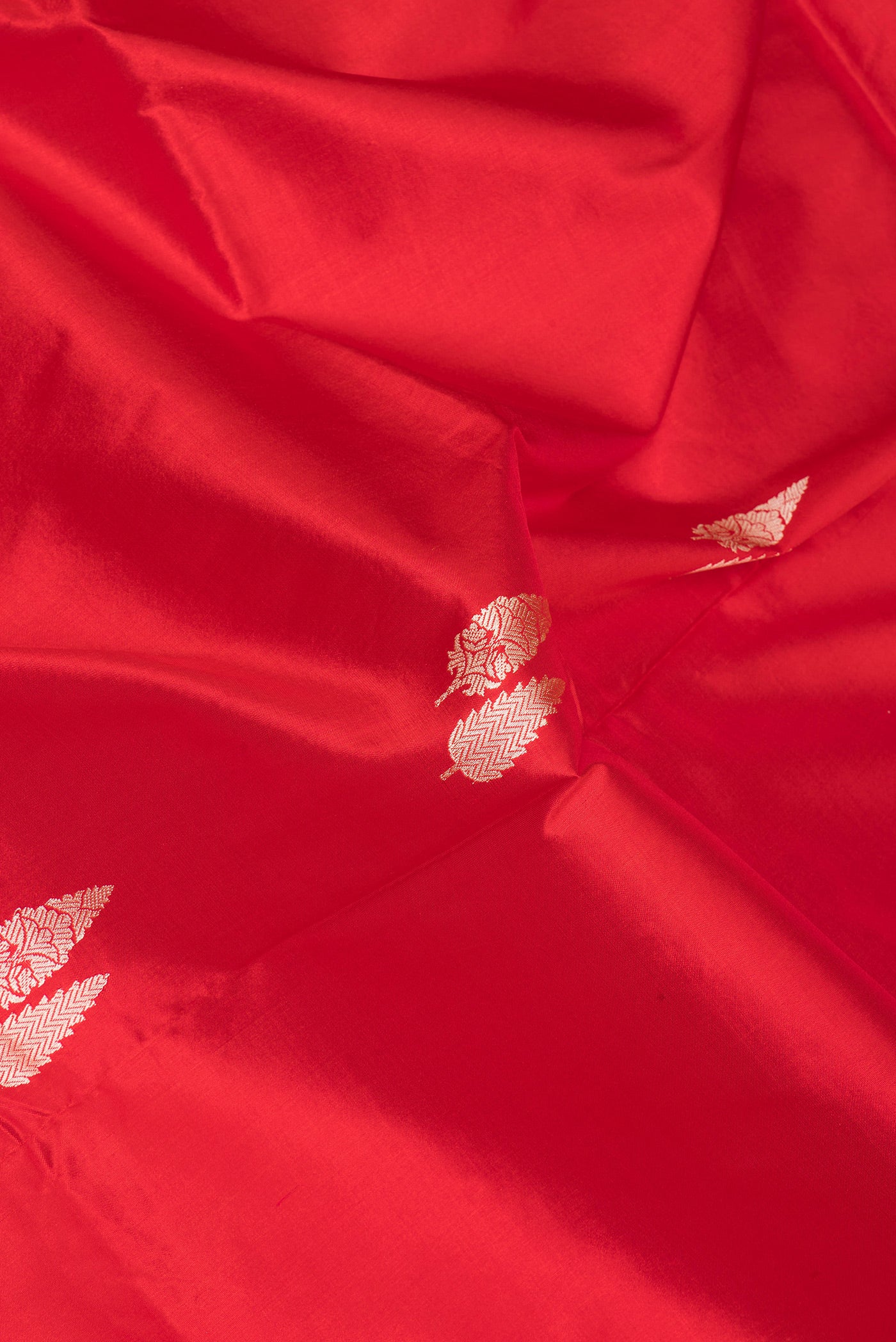 Close up of Red Banarasi Silk Saree with Thread Butta on the body and Thread Border.  displaying folds