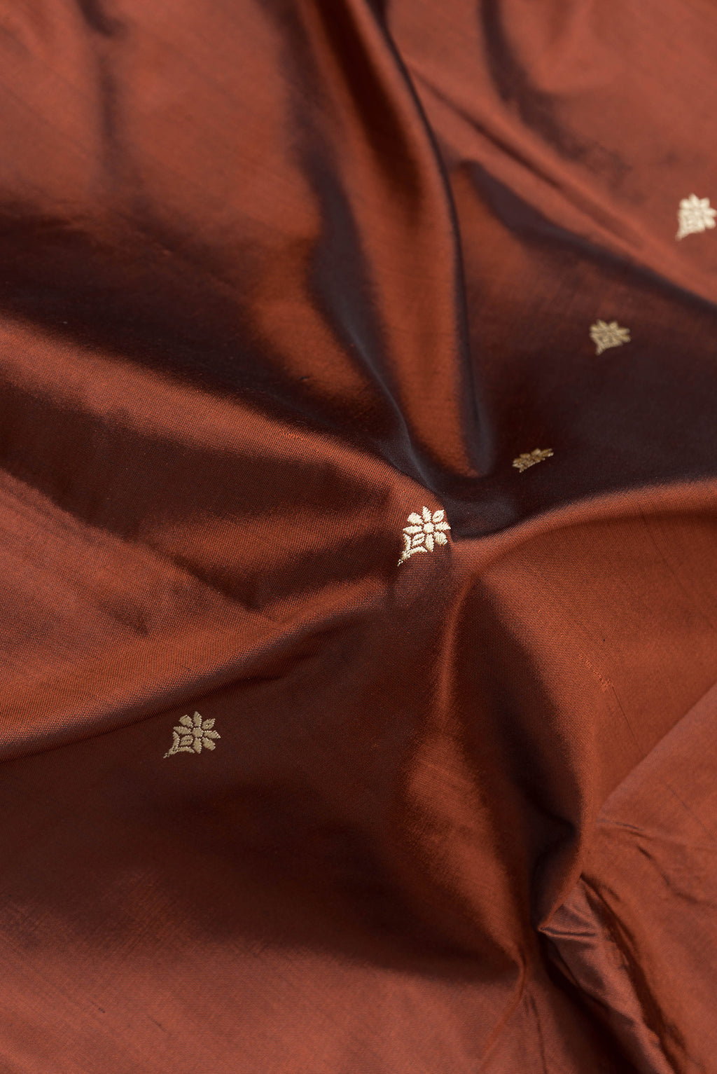 Close up of Brown Dual Tone Banarasi Silk Saree with Thread Butta on the body and Thread Border.  displaying folds