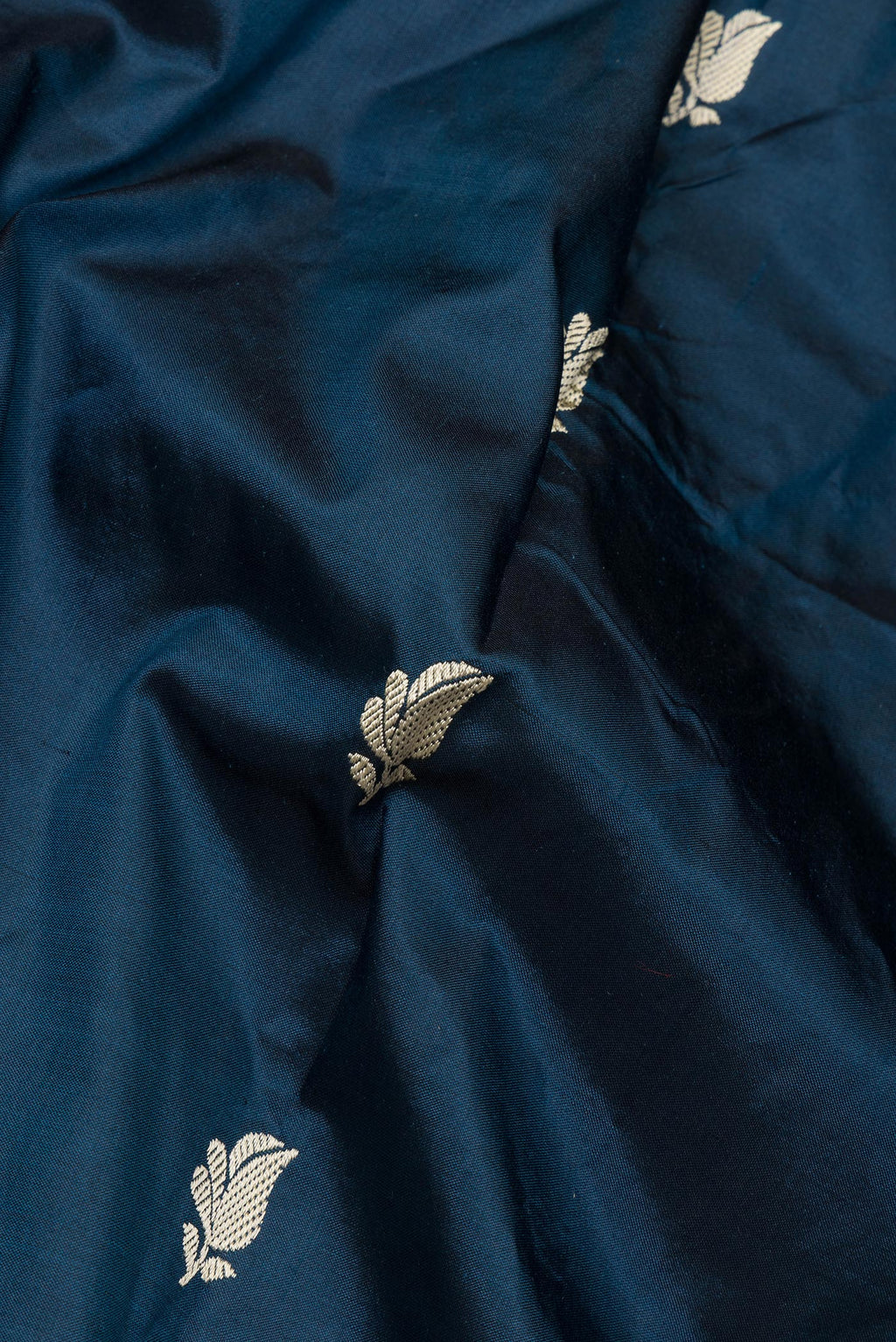 Close up of Pure Silk Peacock Blue Banarasi Katan Saree with Thread Butta on the body and Thread Border.  displaying folds