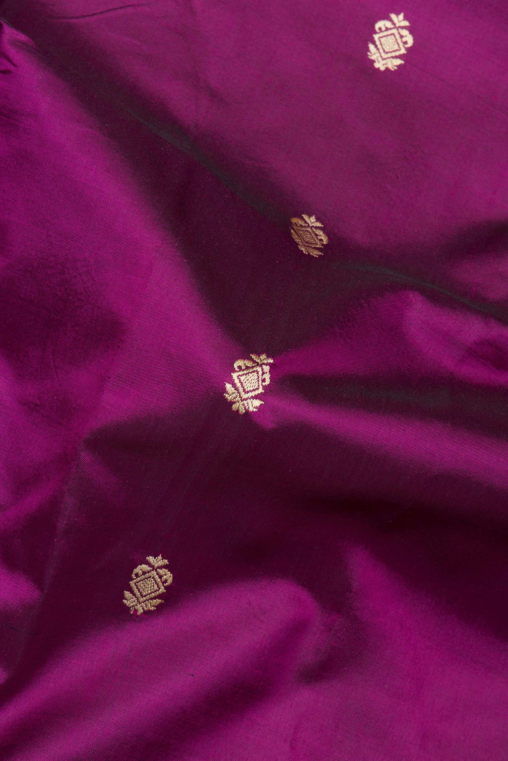 Close up of Pure Silk Magenta Banarasi Katan Saree with Thread Butta on the body and Thread Border.  displaying folds