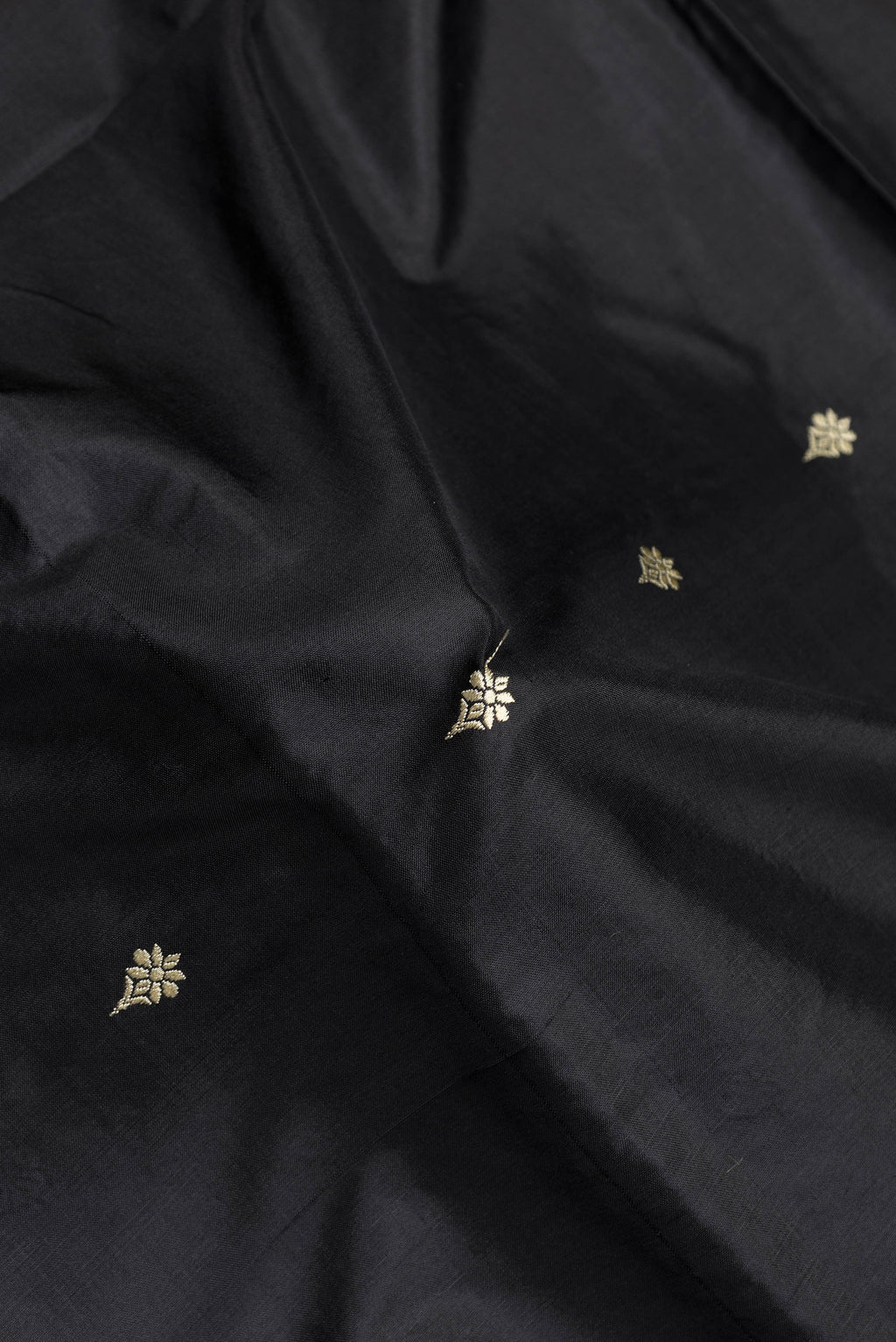Close up of Black Dual Tone Banarasi Silk Saree with Thread Butta on the body and Thread Border.  displaying folds