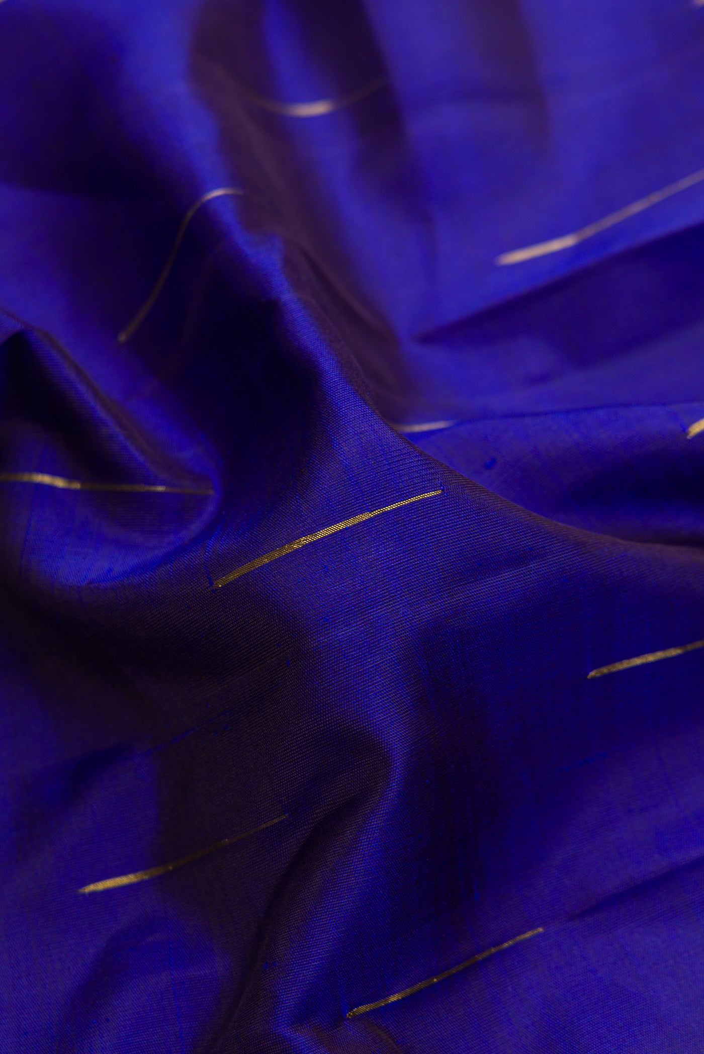 Close up of Navy Blue Dual Tone Kanjivaram Silk Saree with Zari Butta on the body and Thin Zari Line.  displaying folds