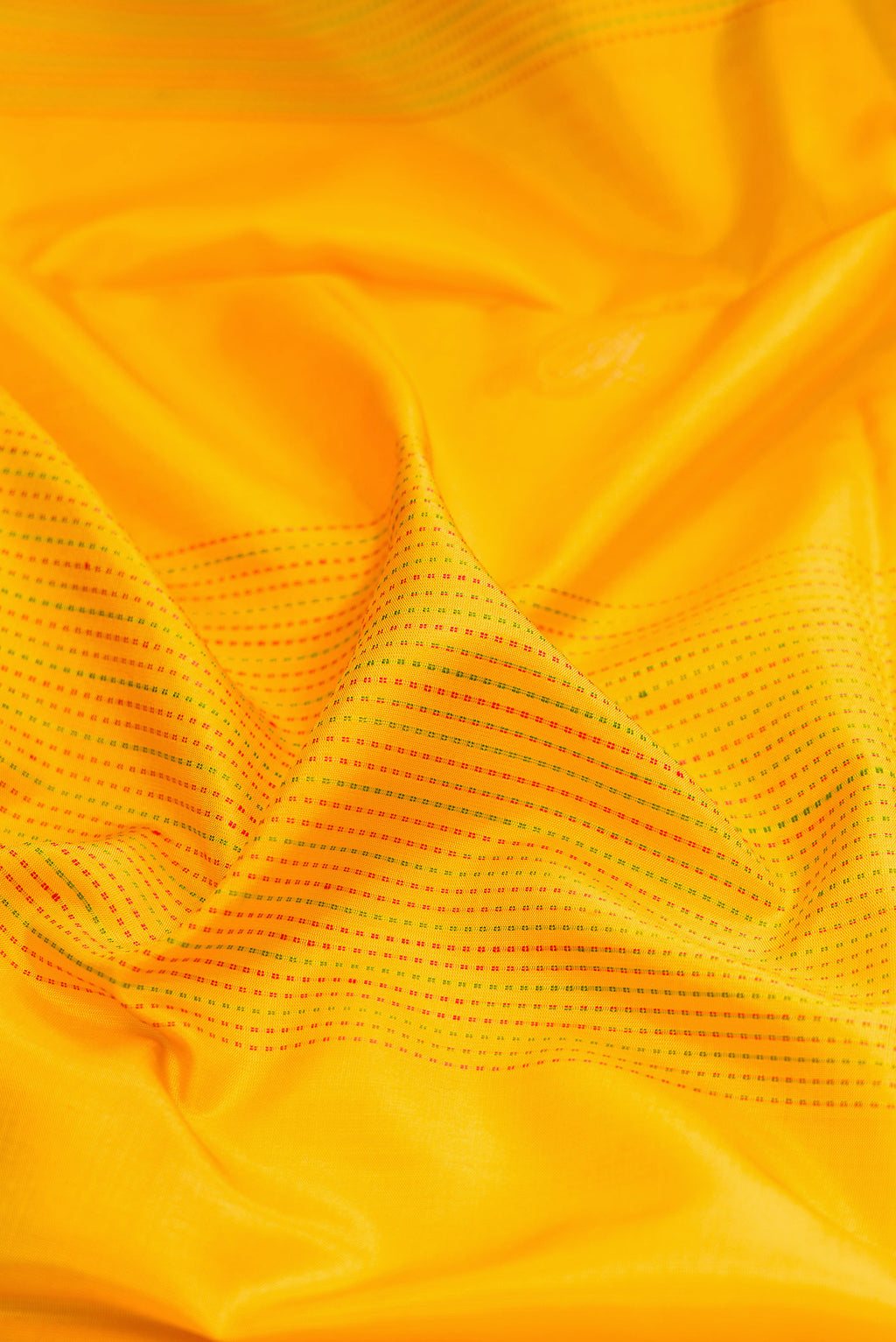 Close up of Yellow Soft Silk Saree with Stripes on the body and Zari Border.  displaying folds