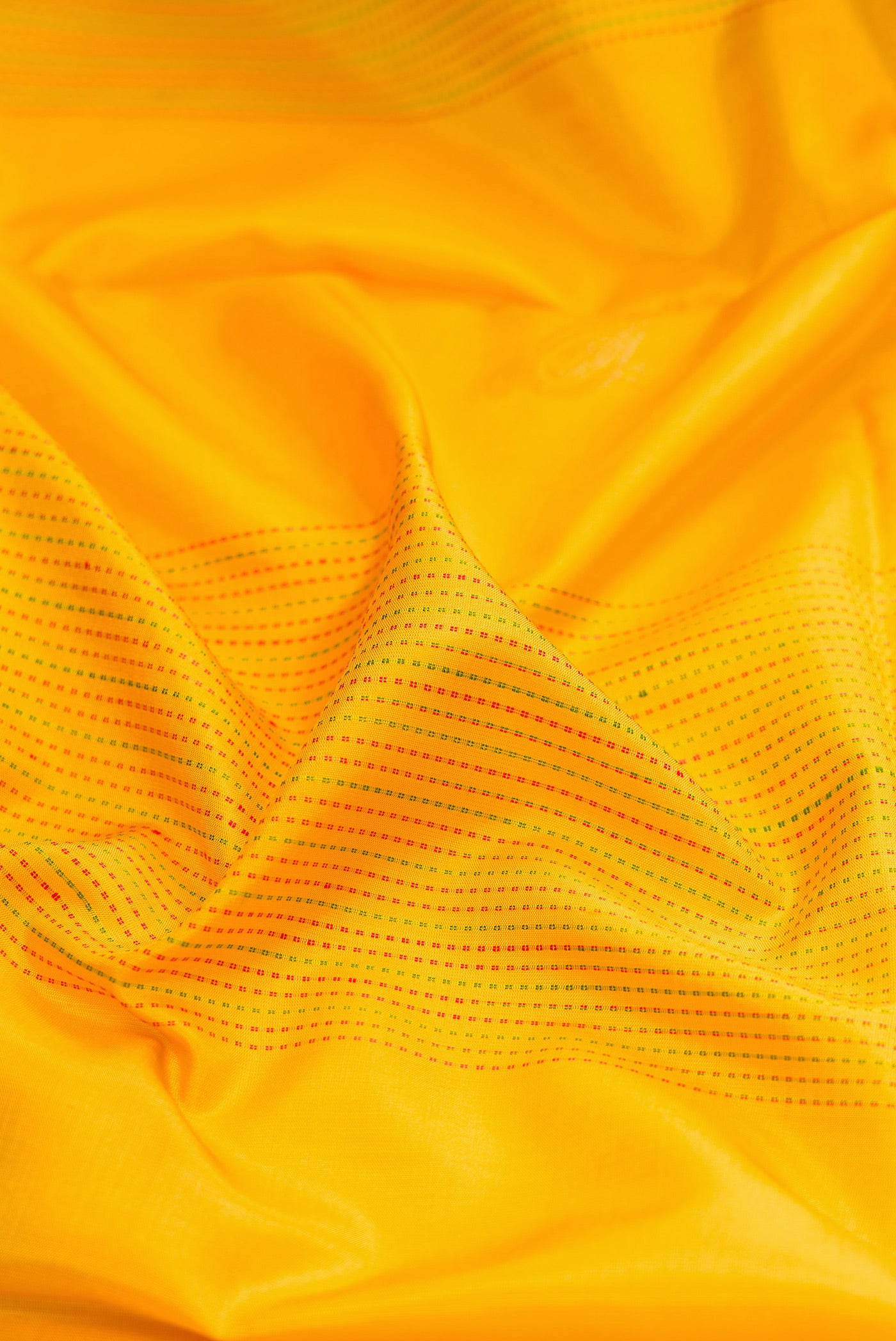 Close up of Yellow Soft Silk Saree with Stripes on the body and Zari Border.  displaying folds