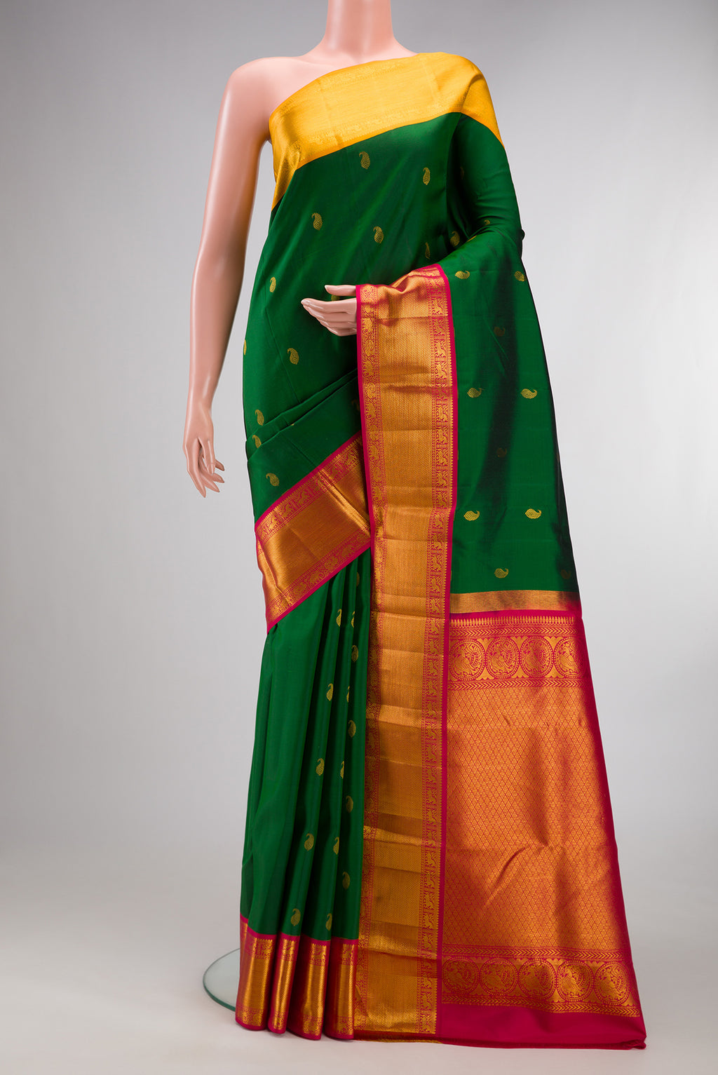 Pure Silk Bottle Green Kanjivaram Saree with Zari Butta on the body and Ganga Jamuna Border.  displayed on a mannequin