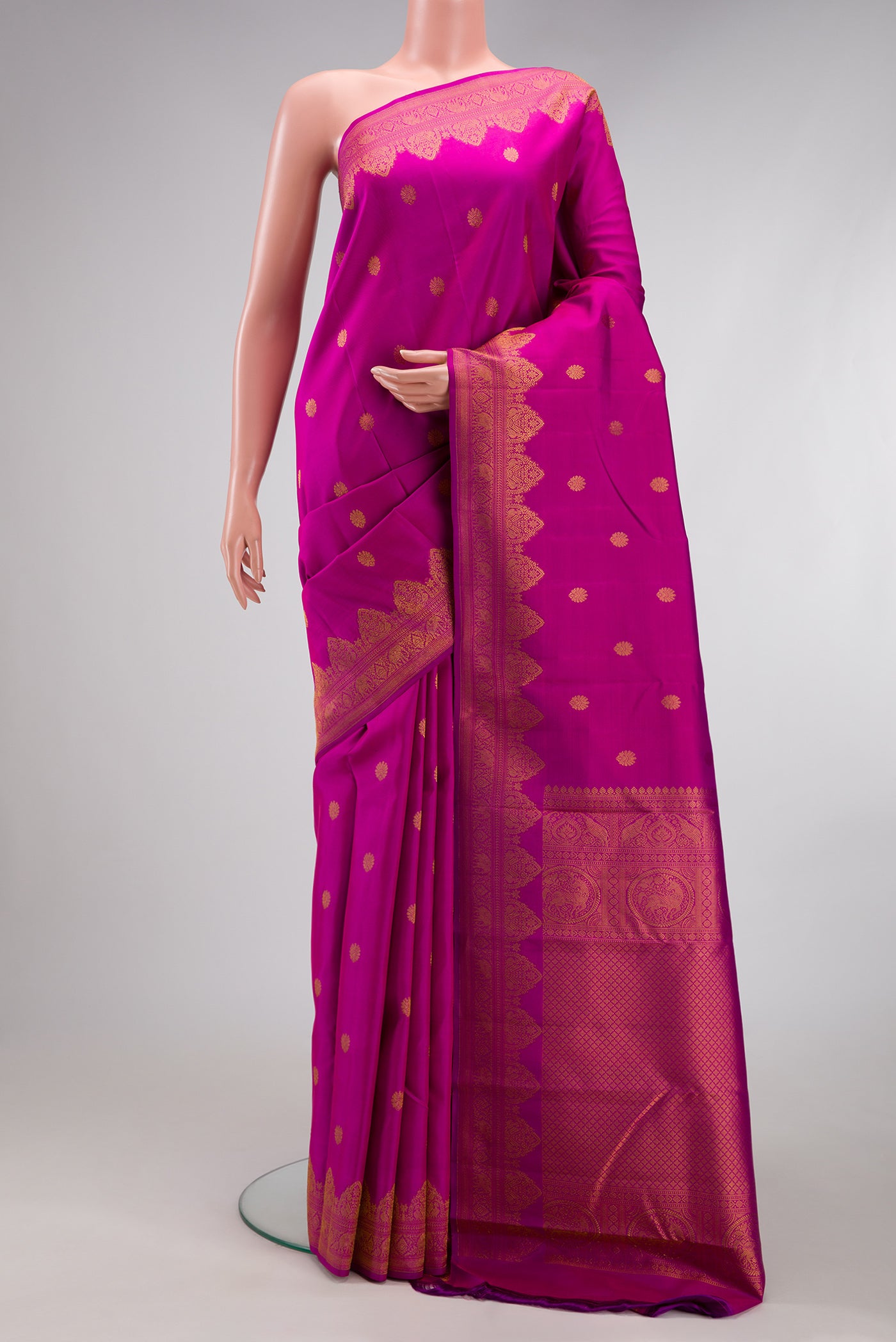 Magenta Kanchipuram Silk Saree with Zari Butta on the body and Fancy Border.  displayed on a mannequin