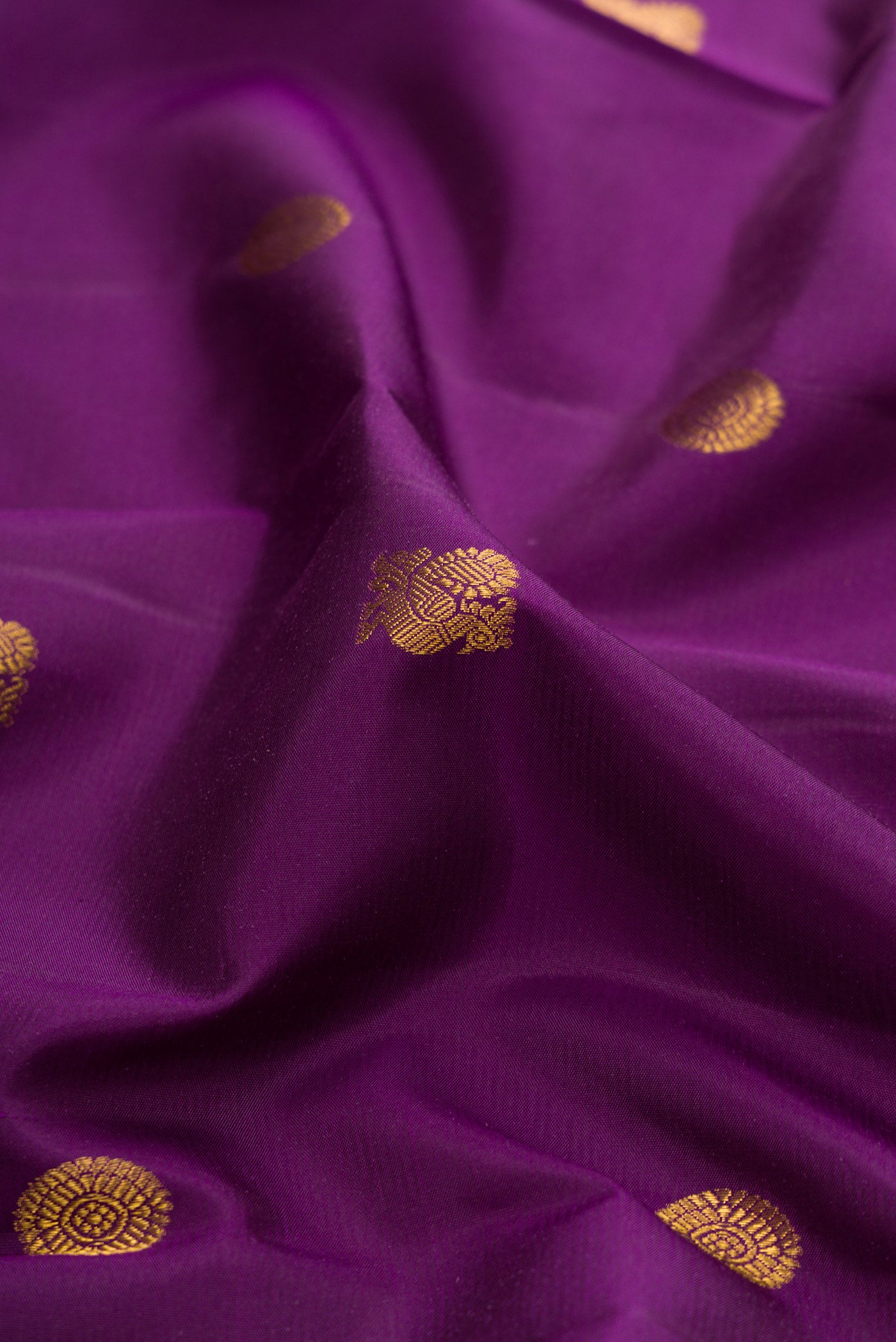 Close up of Purple Kanchipuram Silk Saree with Zari Butta on the body and Zari Border.  displaying folds