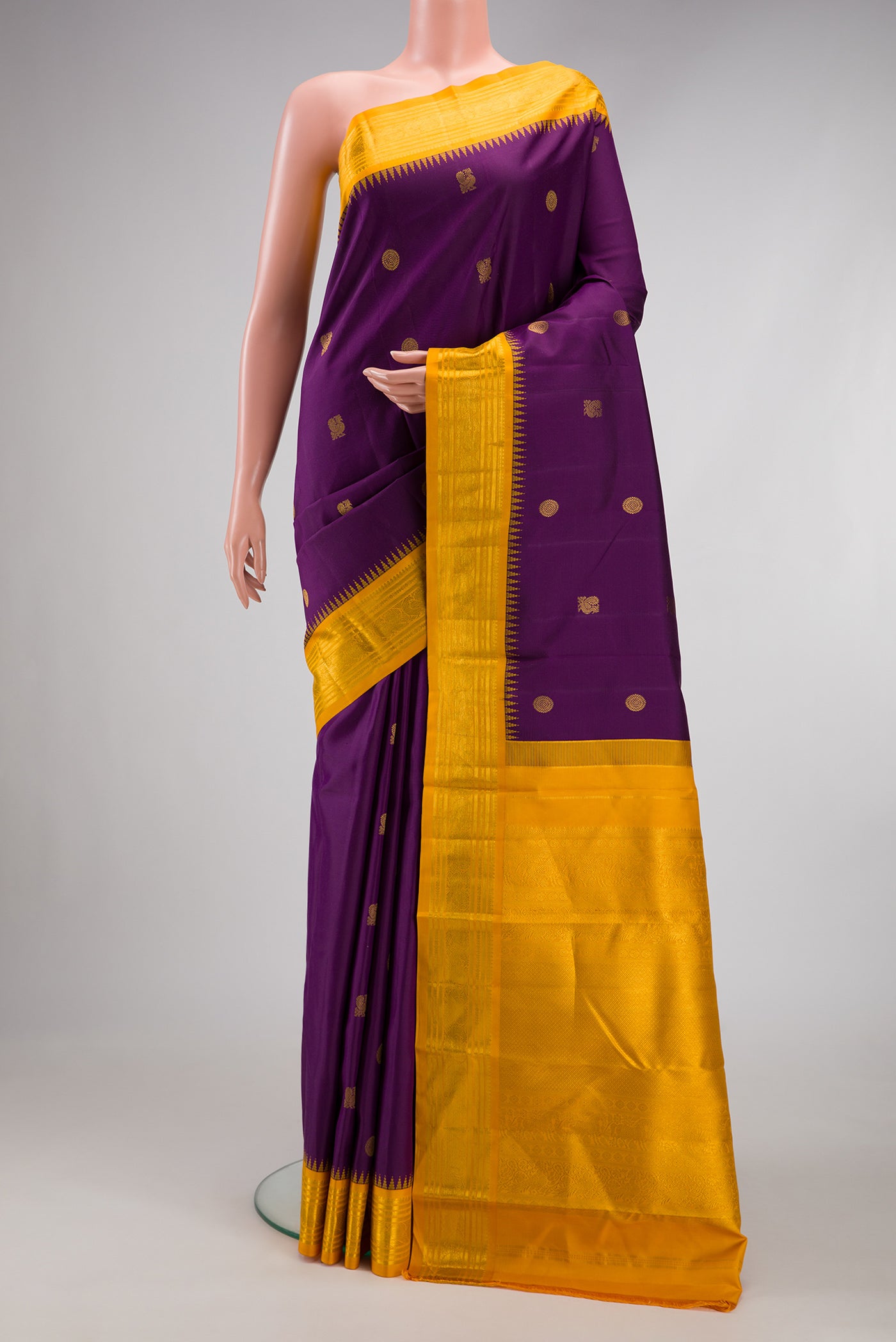 Purple Kanchipuram Silk Saree with Zari Butta on the body and Zari Border.  displayed on a mannequin