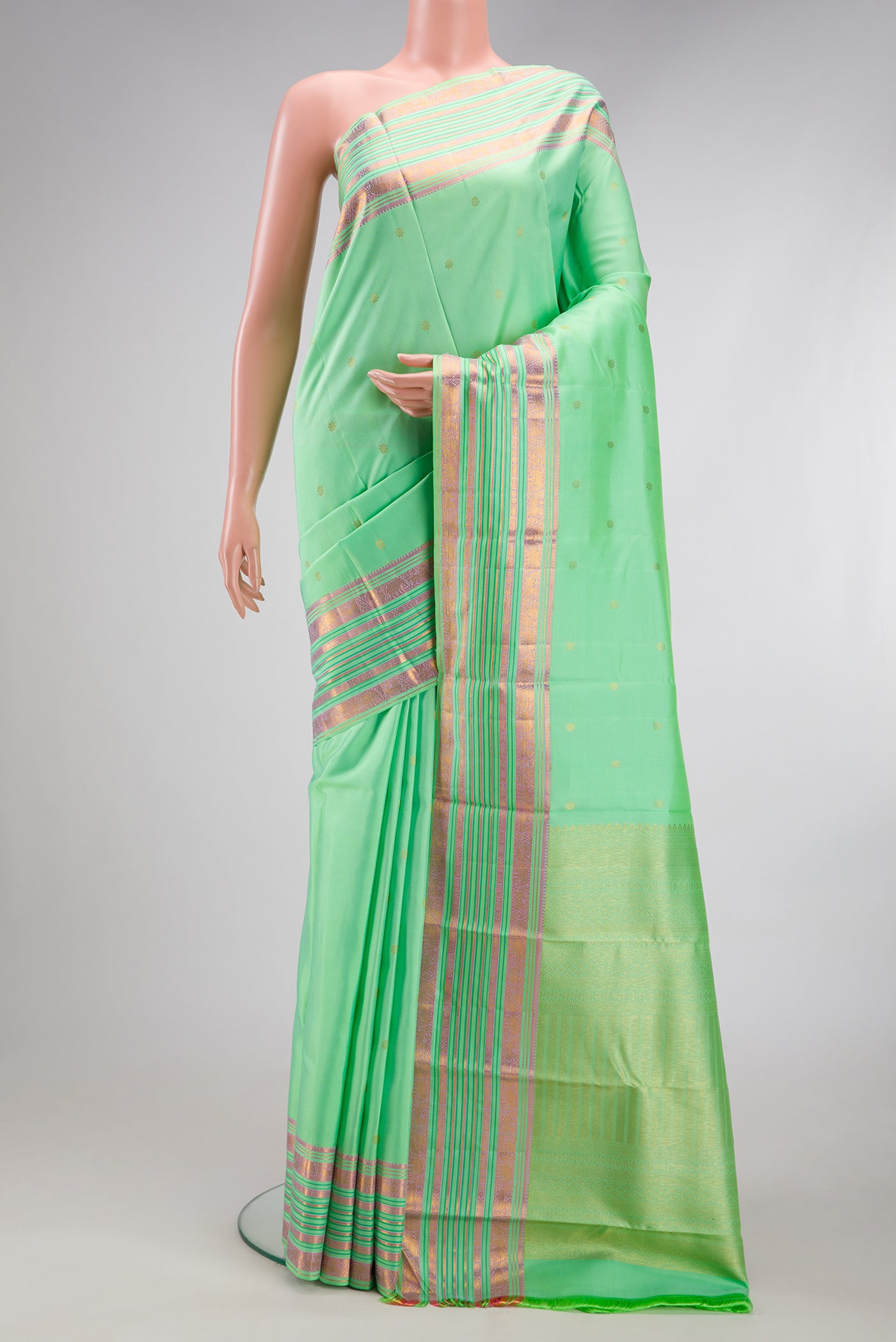 Pista Green Kanchipuram Silk Saree with Zari Butta on the body and Fancy Border.  displayed on a mannequin