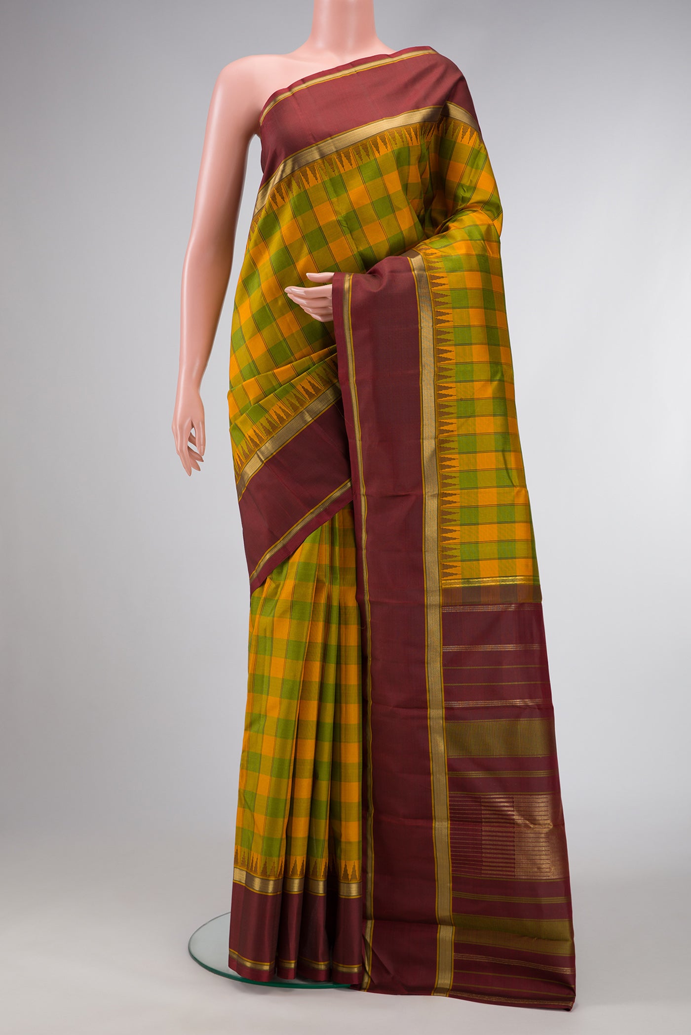 Pure Silk Pure Zari Green and Yellow Color Kanchipuram Saree with Checked design on the body and Temple Border.  displayed on a mannequin