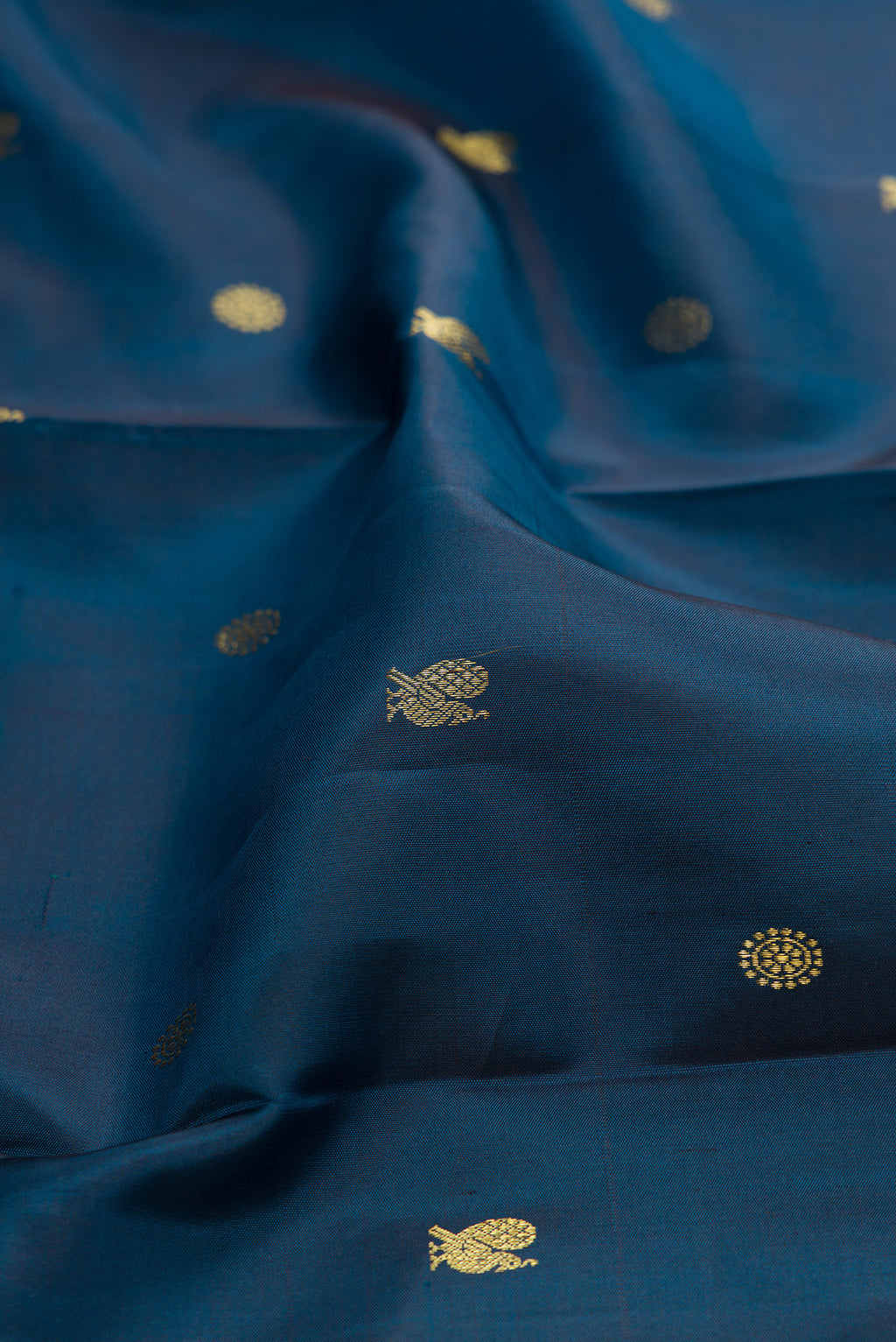 Close up of Peacock Blue Kanchipuram Silk Saree with Zari Butta on the body and Zari Border.  displaying folds