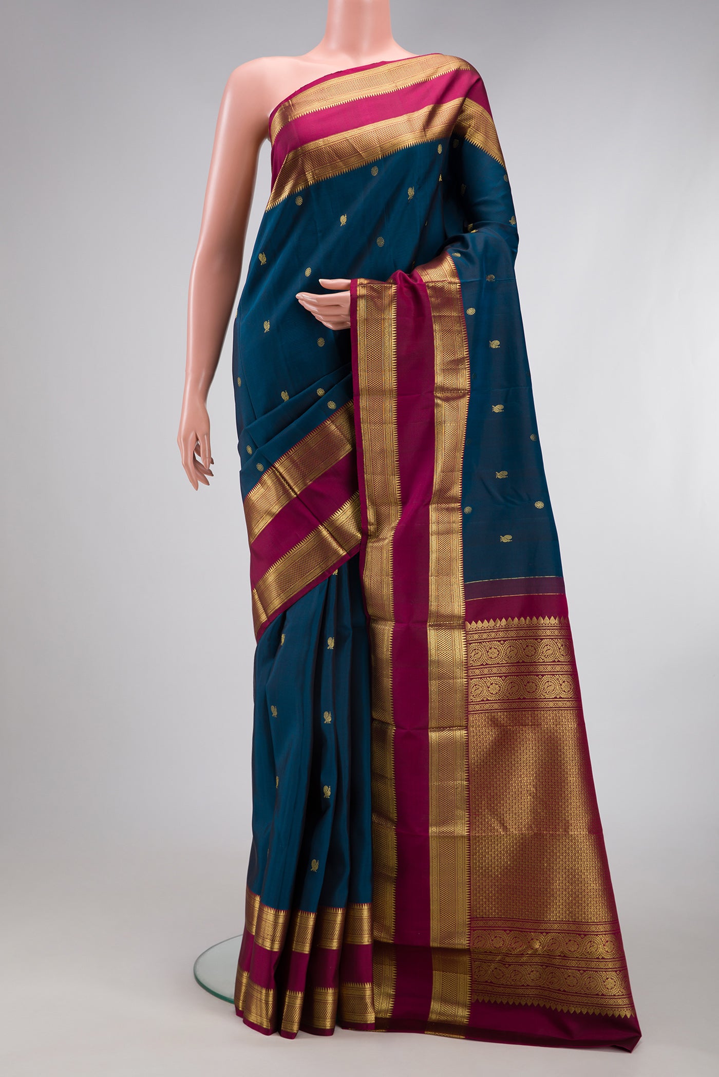 Peacock Blue Kanchipuram Silk Saree with Zari Butta on the body and Zari Border.  displayed on a mannequin