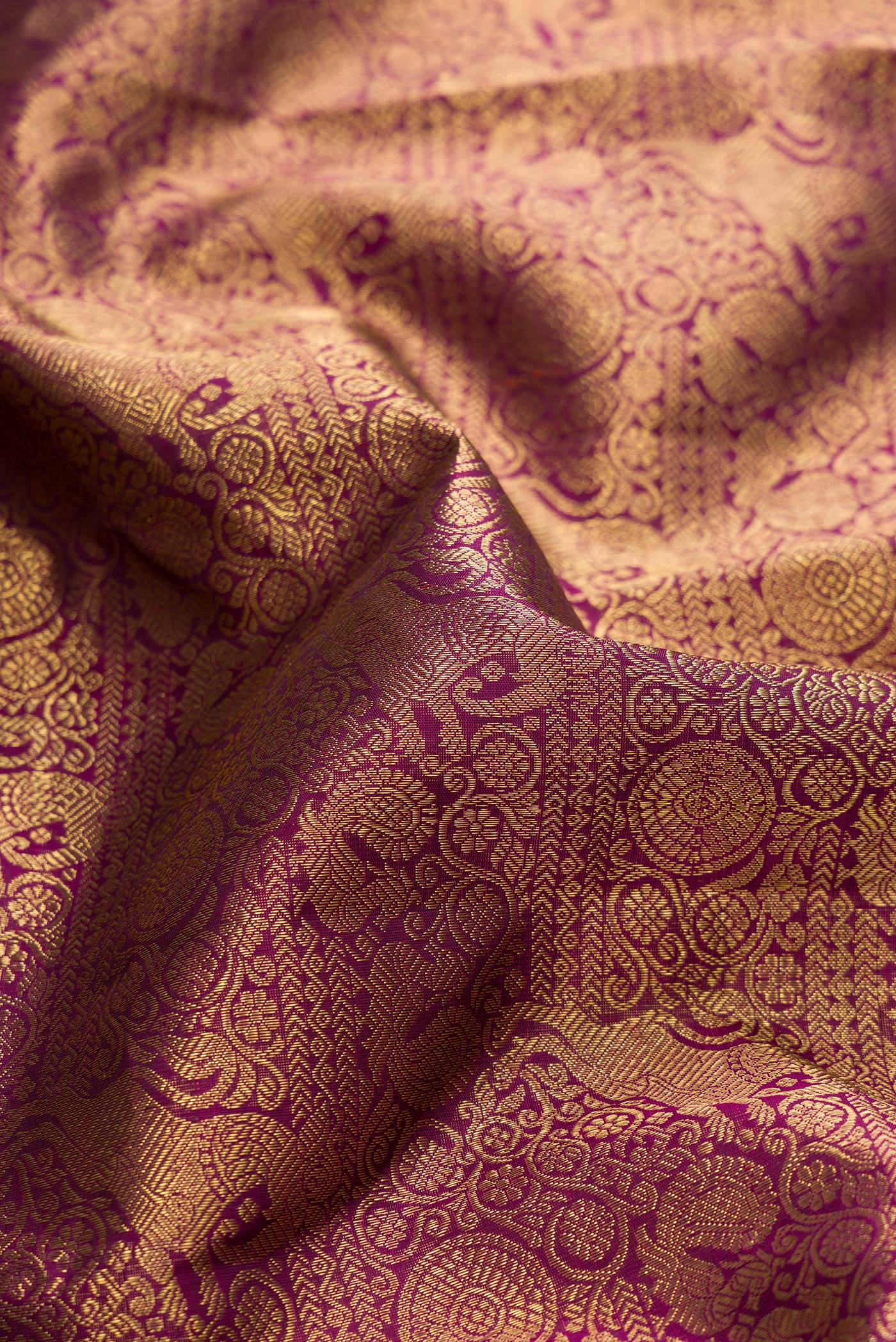 Close up of Pure Silk Pure Zari Burgundy Dual Tone Kanjivaram Saree with Zari Brocade on the body and Zari Border.  displaying folds
