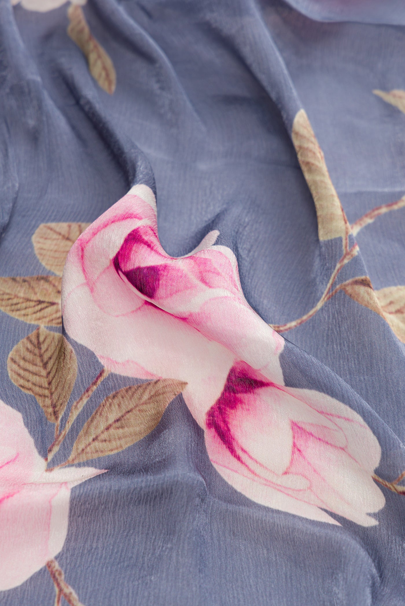 Close up of Grey Dual Tone Organza Silk Saree with Printed design on the body and Embroidery Border.  displaying folds