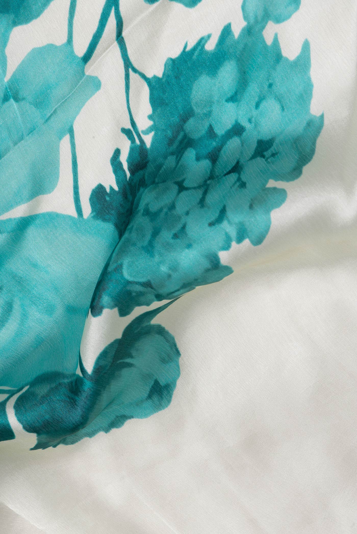 Close up of Off White Dual Tone Mysore Crepe Saree with Printed design on the body and Embroidery Border.  displaying folds