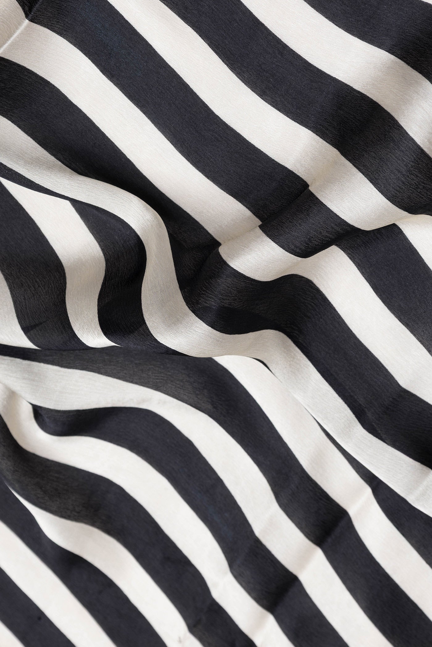 Close up of Black and Off White Color Crepe Saree with Stripes on the body and Embroidery Border.  displaying folds