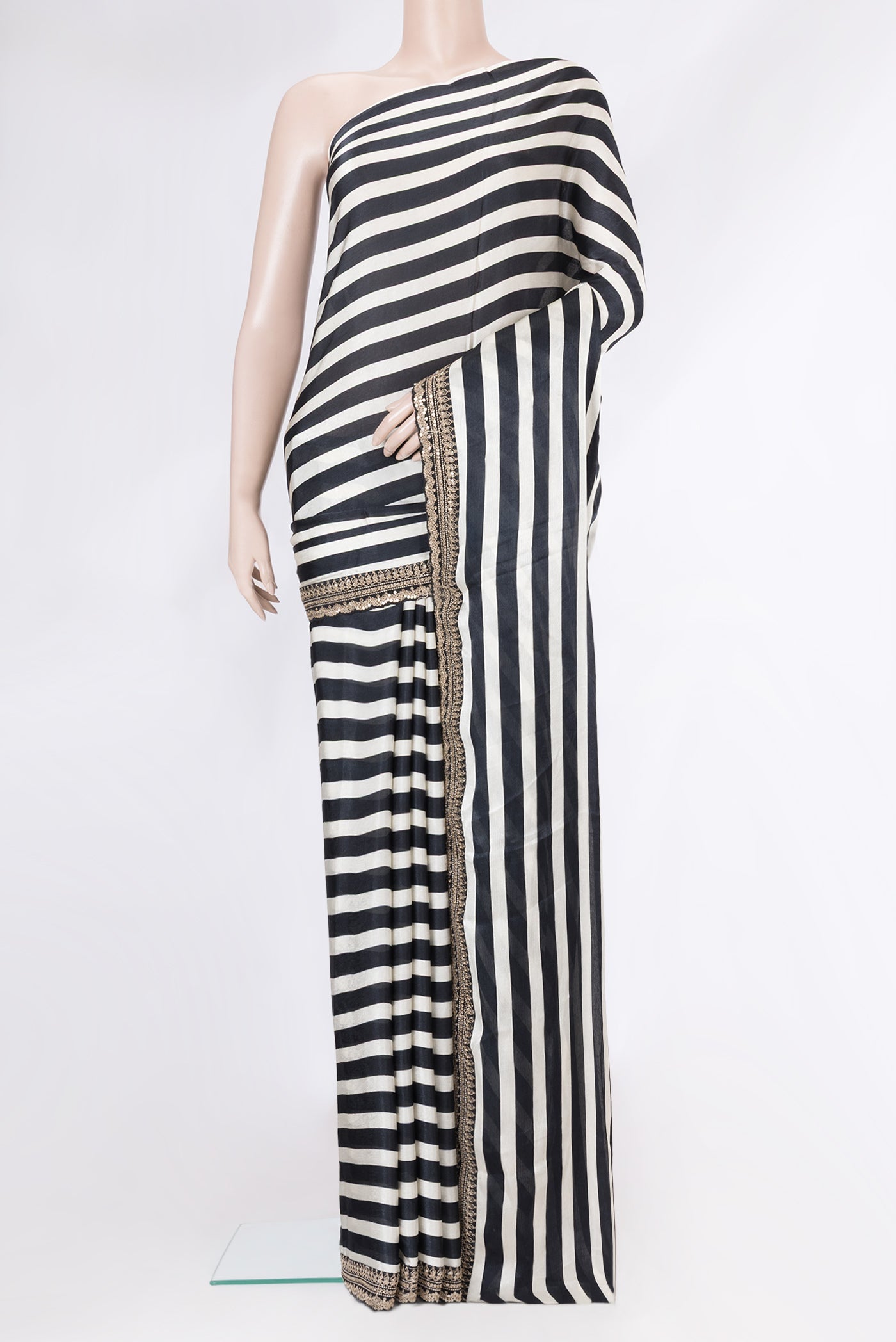 Black and Off White Color Crepe Saree with Stripes on the body and Embroidery Border.  displayed on a mannequin