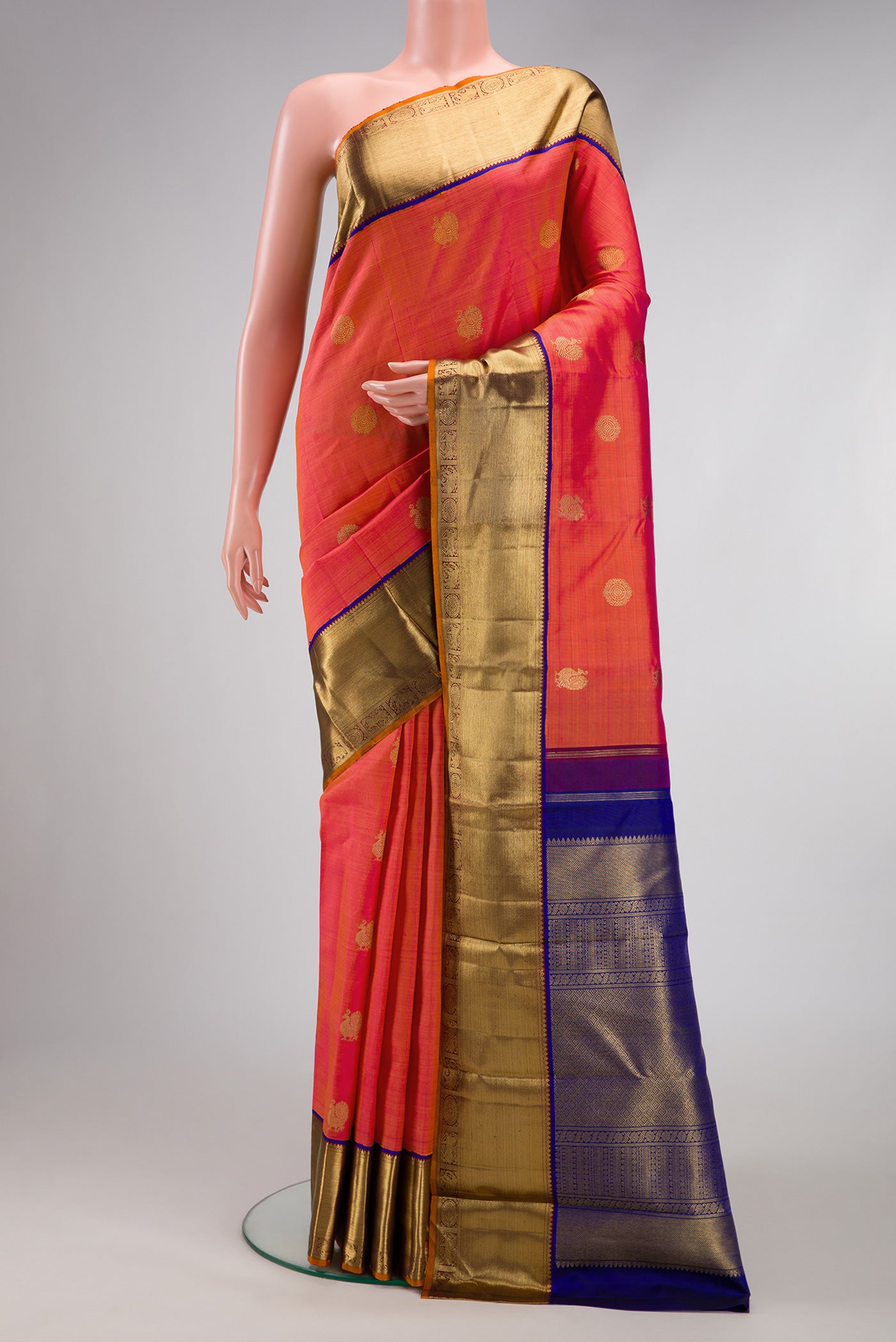 Pure Silk Pure Zari Coral Dual Tone Kanjivaram Saree with Zari Butta on the body and Zari Border.  displayed on a mannequin