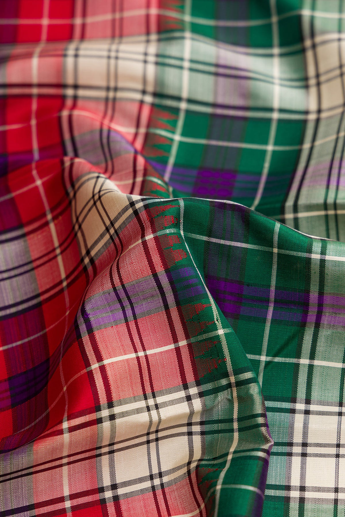 Close up of Red and Green Color Kanjivaram Silk Saree with Checked design on the body and Without Border.  displaying folds