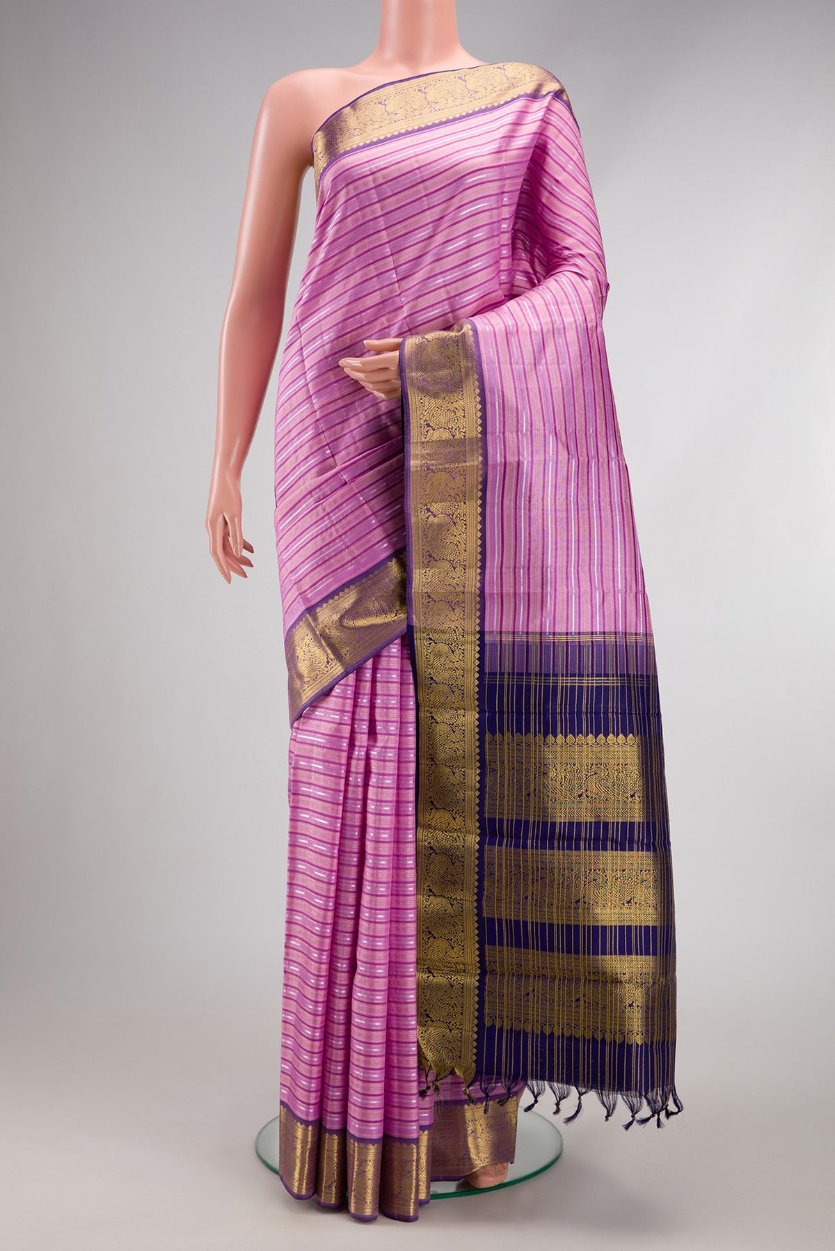Lavender Kanchipuram Silk Saree with Stripes on the body and Zari Border.  displayed on a mannequin
