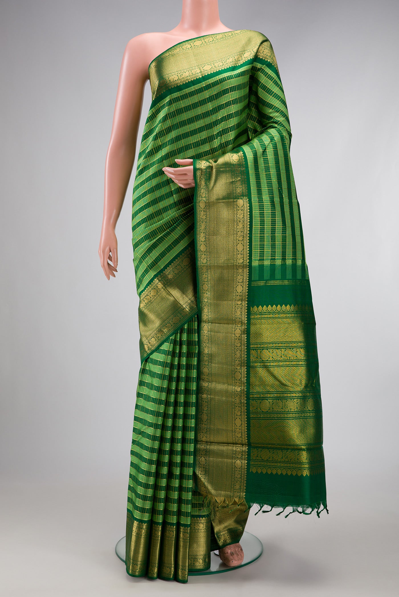 Green Kanchipuram Silk Saree with Stripes on the body and Zari Border.  displayed on a mannequin