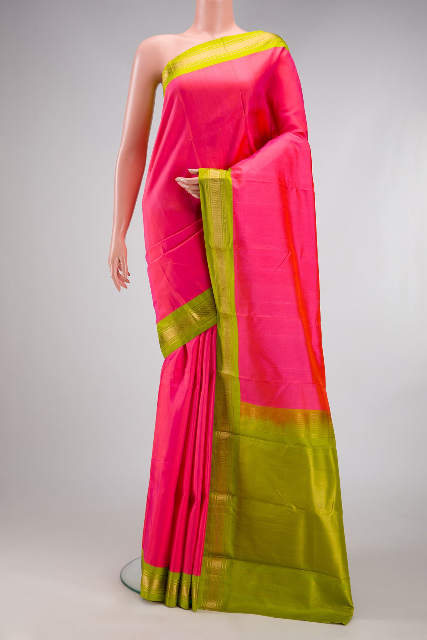 Coral Kanchipuram Silk Saree with Plain Body and Zari Border.  displayed on a mannequin