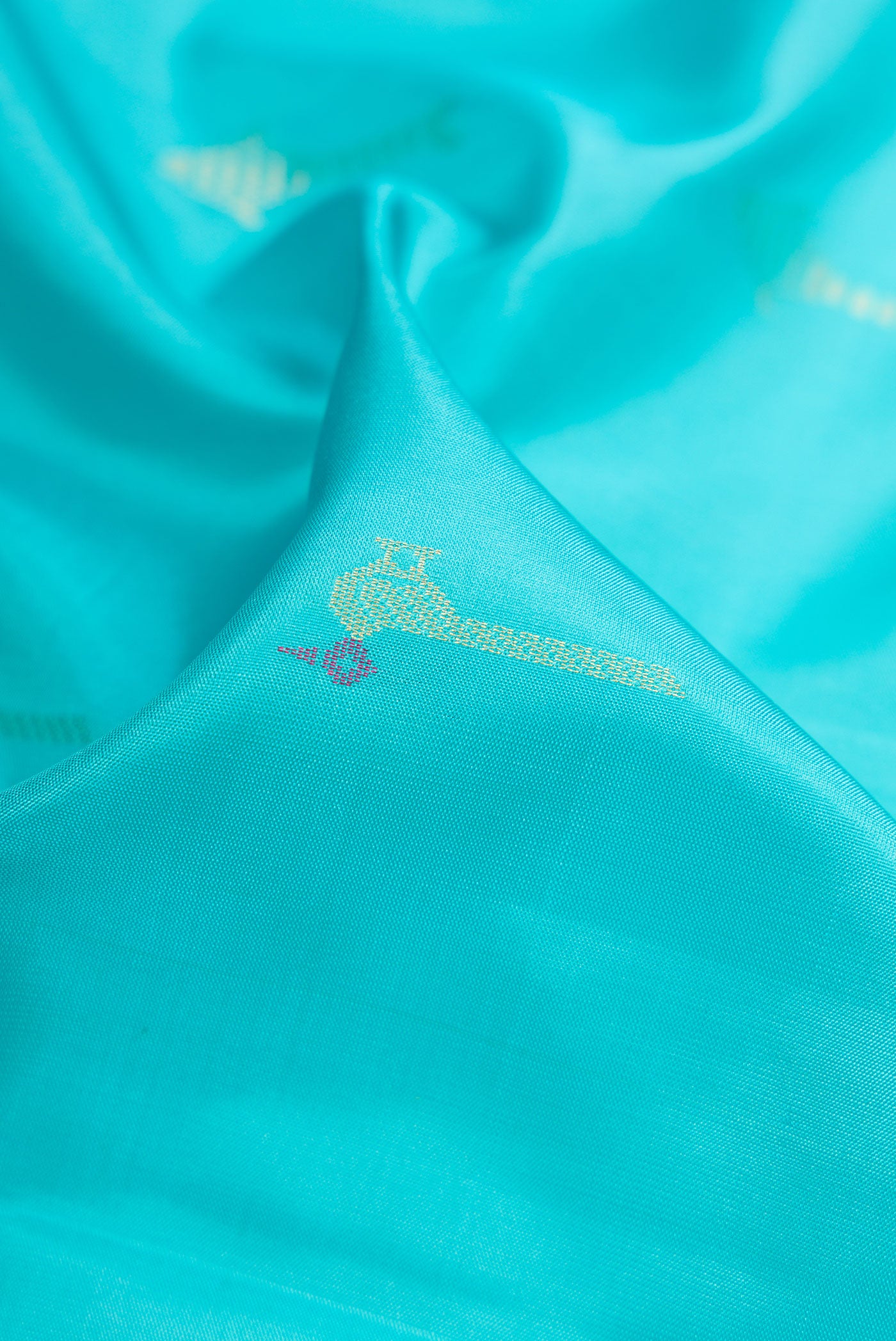 Close up of Sky Blue Soft Silk Saree with Zari Butta on the body and Zari Border.  displaying folds