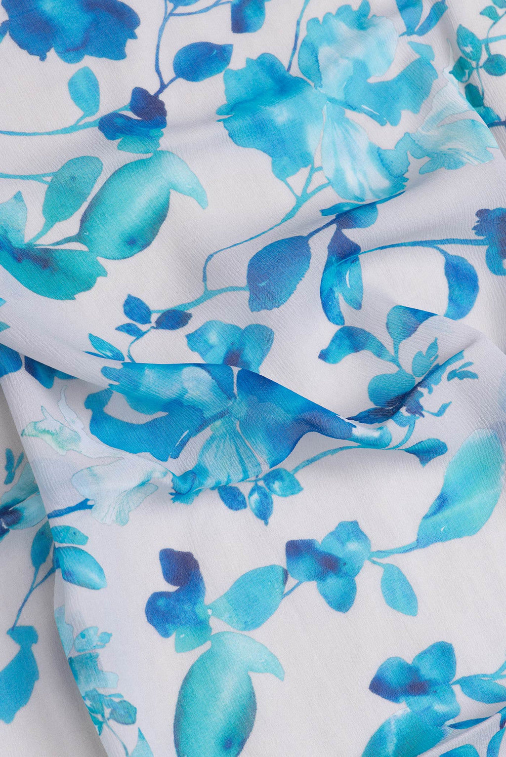 Close up of Off White Dual Tone Crepe Saree with Printed design on the body and Without Border.  displaying folds