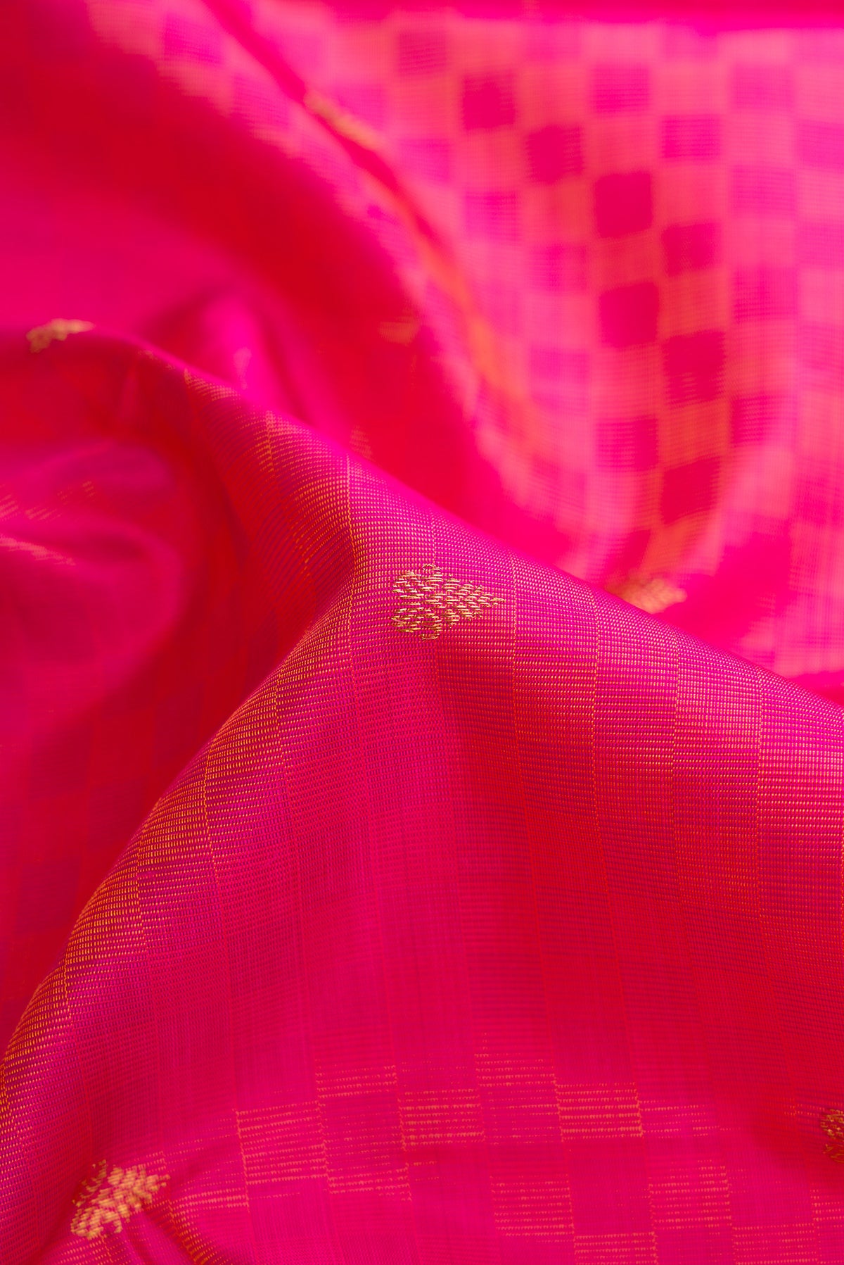 Close up of Pure Silk Pure Zari Peach Dual Tone Kanchipuram Saree with Zari Butta on the body and Fancy Border.  displaying folds