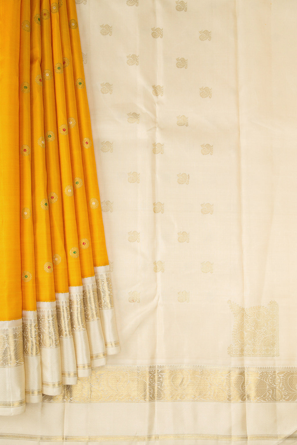 Pleats and pallu of Pure Silk Pure Zari Mustard Dual Tone Kanjivaram Saree with Zari And Thread Butta on the body and Zari Border. 