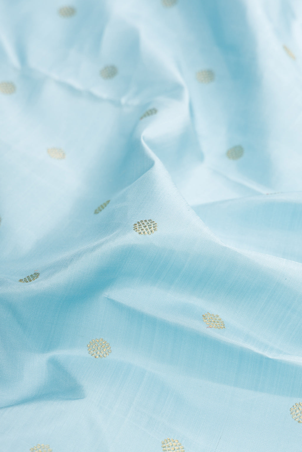 Close up of Pure Silk Pure Zari Sky Blue Dual Tone Kanjivaram Saree with Zari Butta on the body and Zari Border.  displaying folds