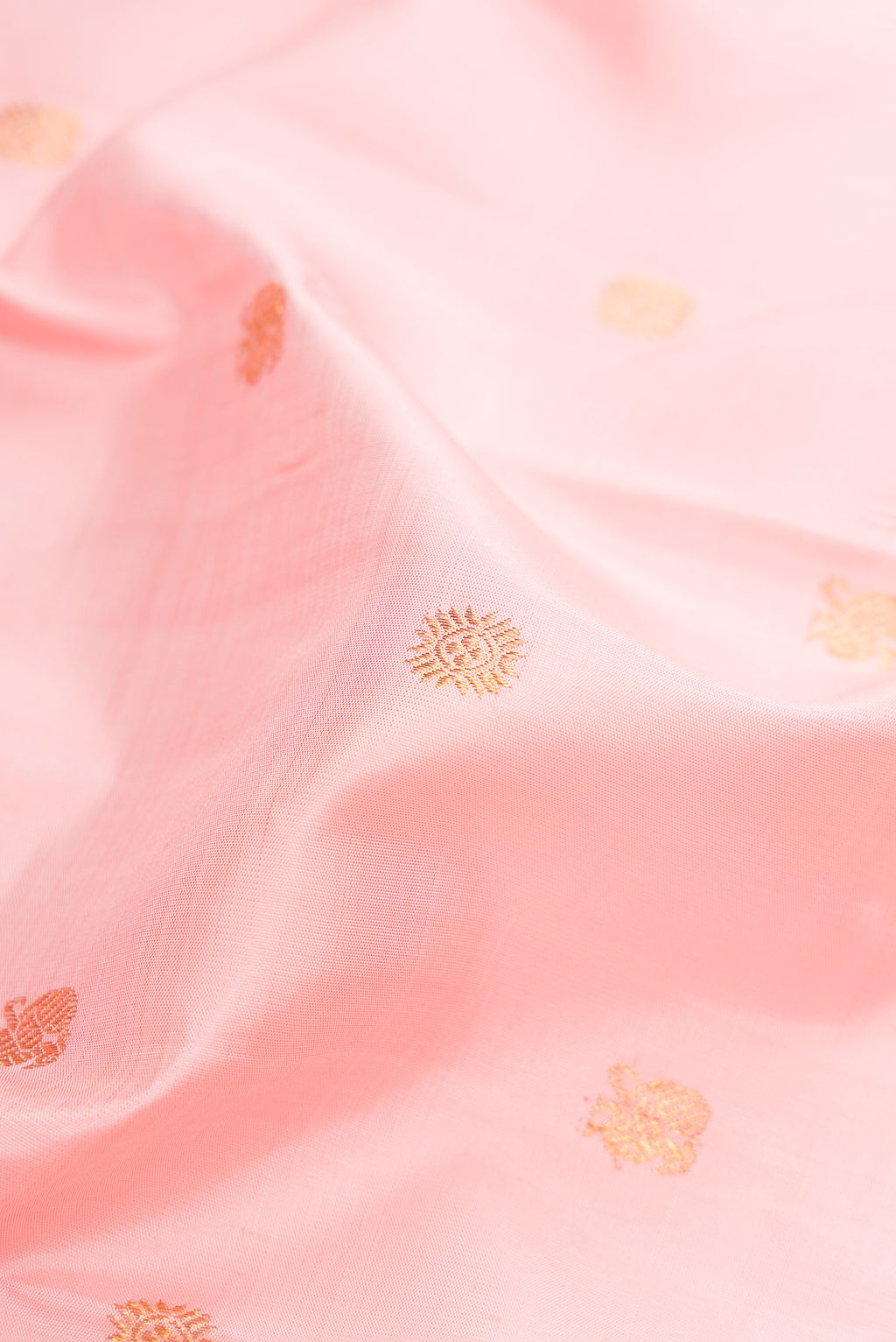 Close up of Pure Silk Pure Zari Rose pink Kanjivaram Saree with Zari Butta on the body and Zari Border.  displaying folds