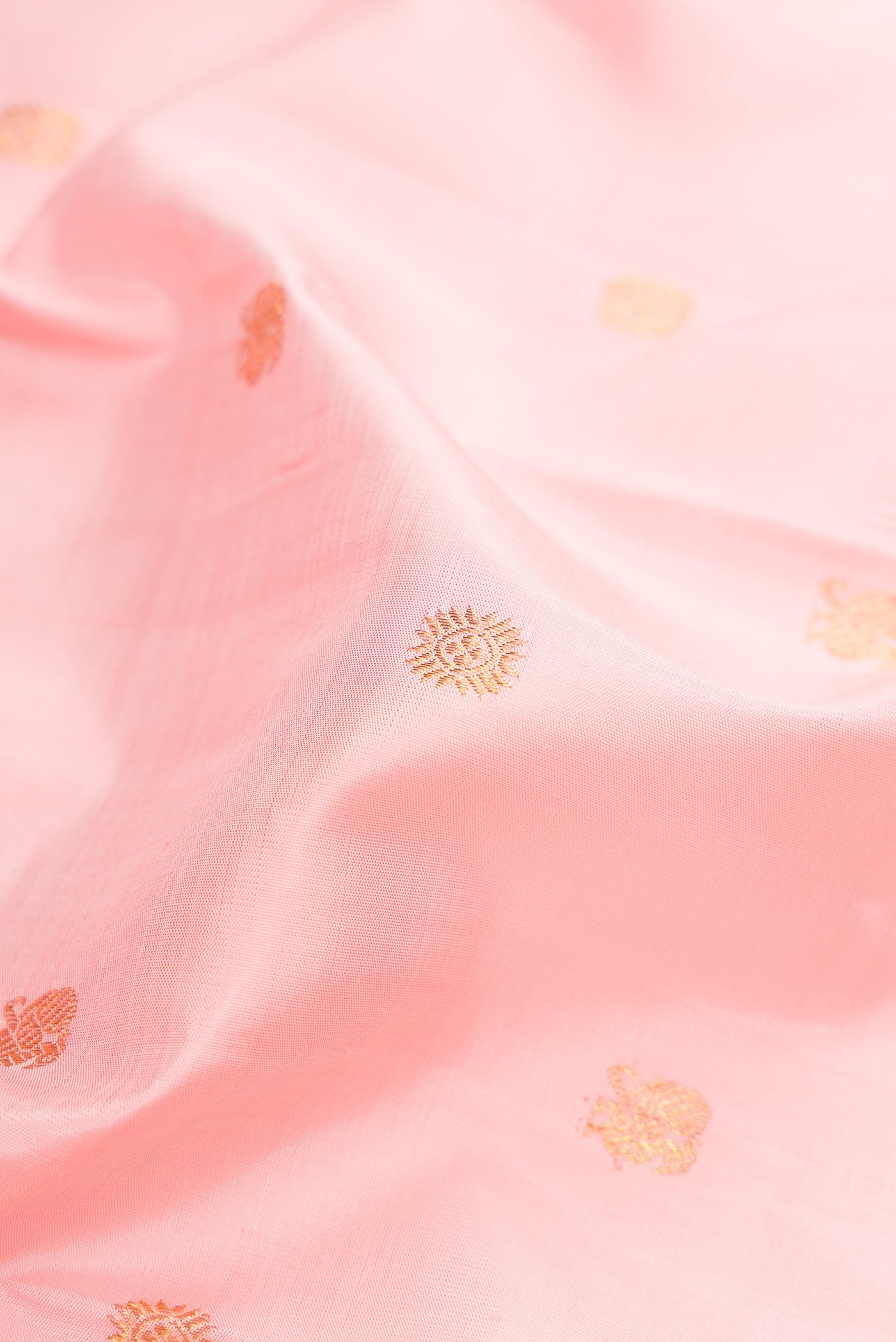 Close up of Pure Silk Pure Zari Rose pink Kanjivaram Saree with Zari Butta on the body and Zari Border.  displaying folds