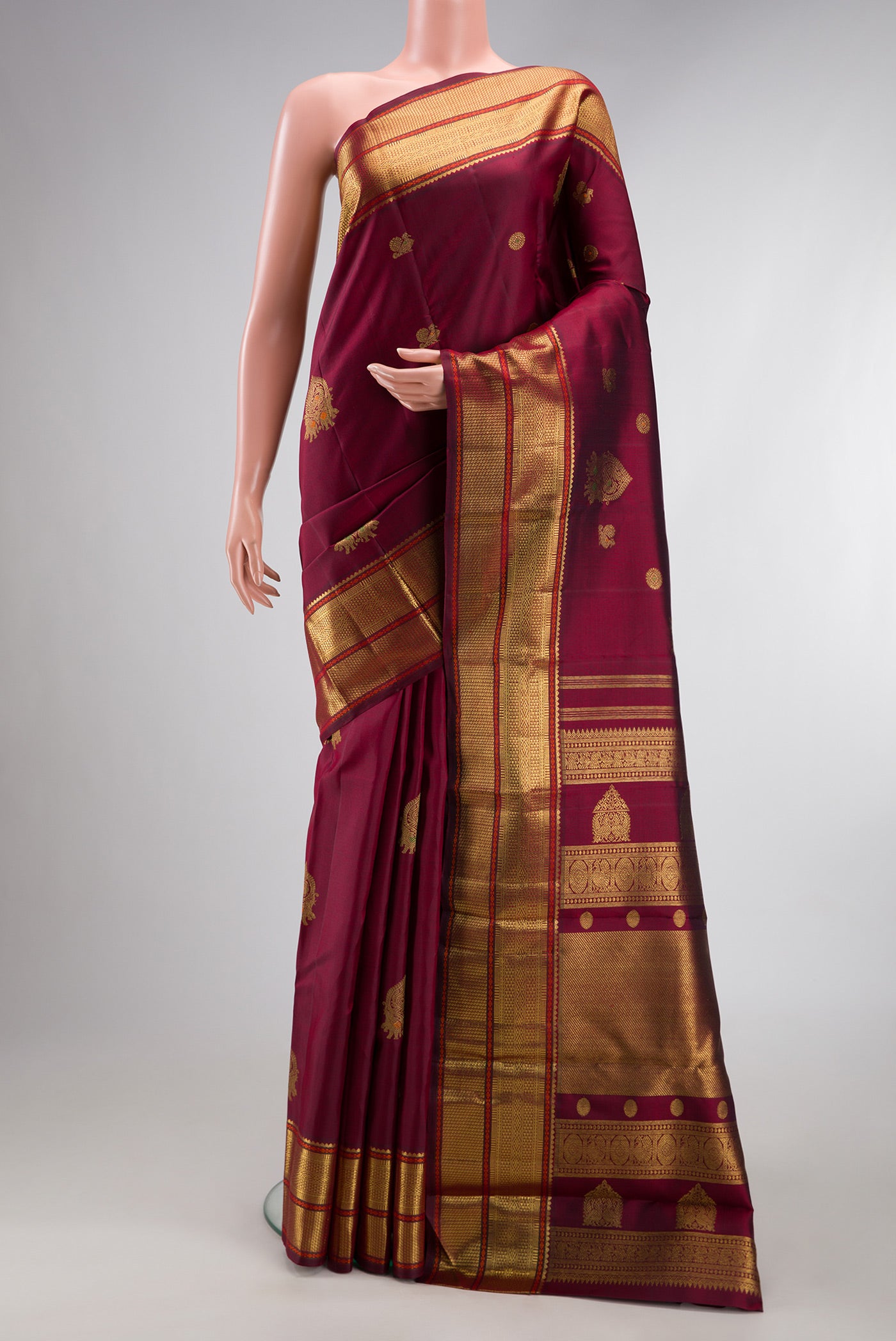 Pure Silk Pure Zari Maroon Kanjivaram Saree with Zari Butta on the body and Zari Border.  displayed on a mannequin
