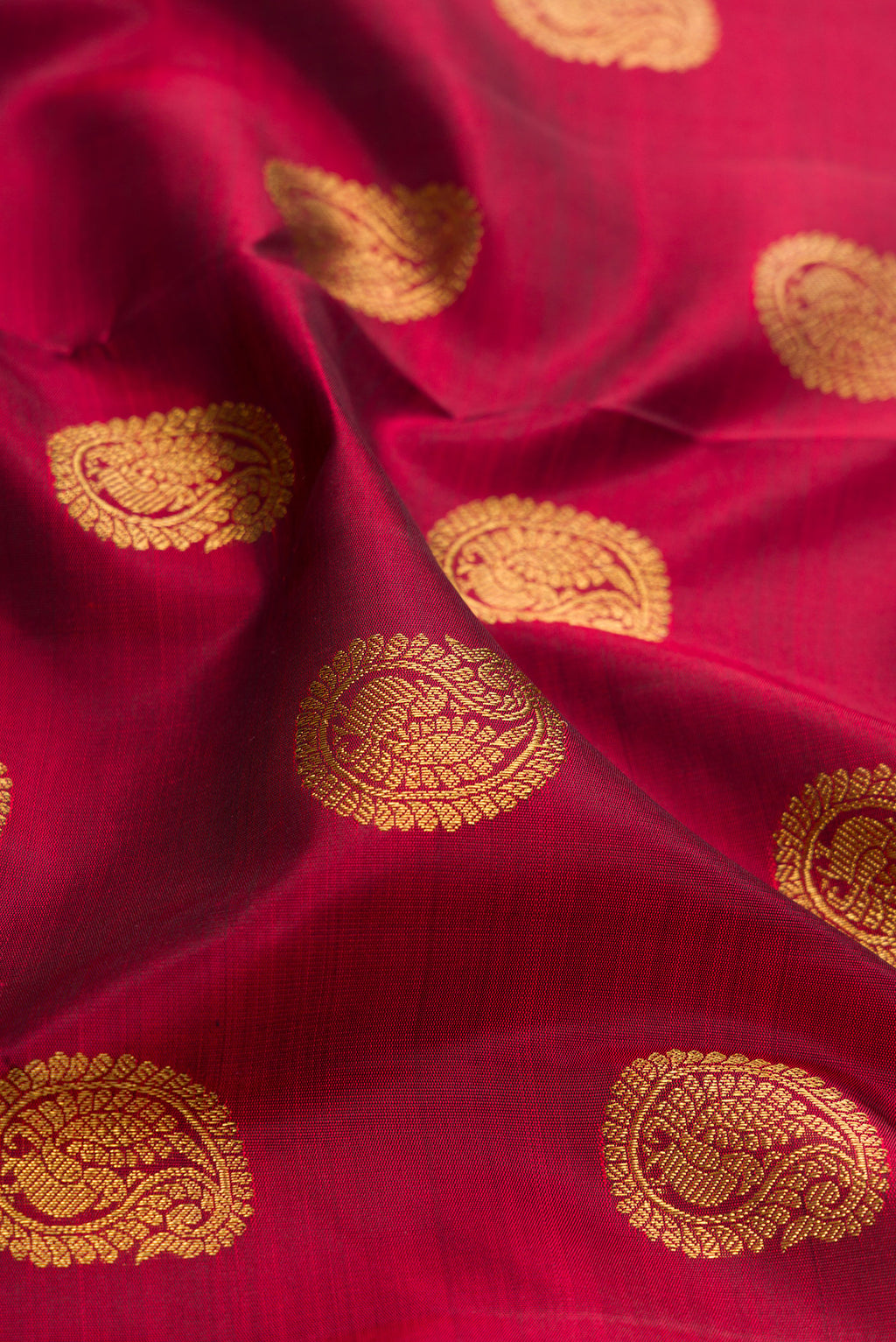 Close up of Pure Silk Pure Zari Maroon Kanjivaram Saree with Zari Butta on the body and Zari Border.  displaying folds