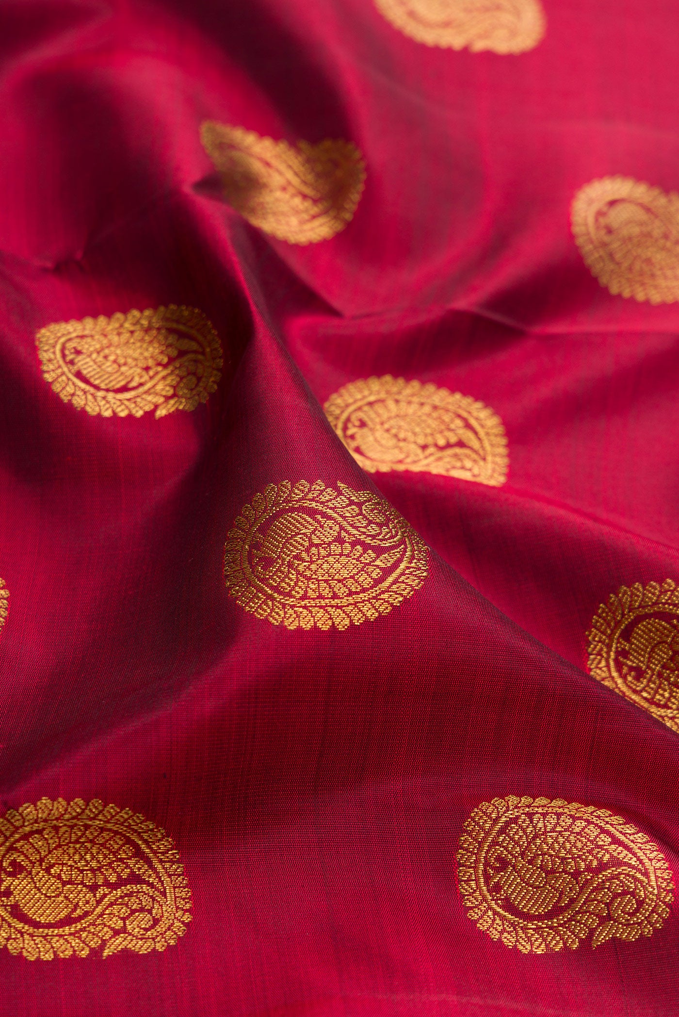 Close up of Pure Silk Pure Zari Maroon Kanjivaram Saree with Zari Butta on the body and Zari Border.  displaying folds