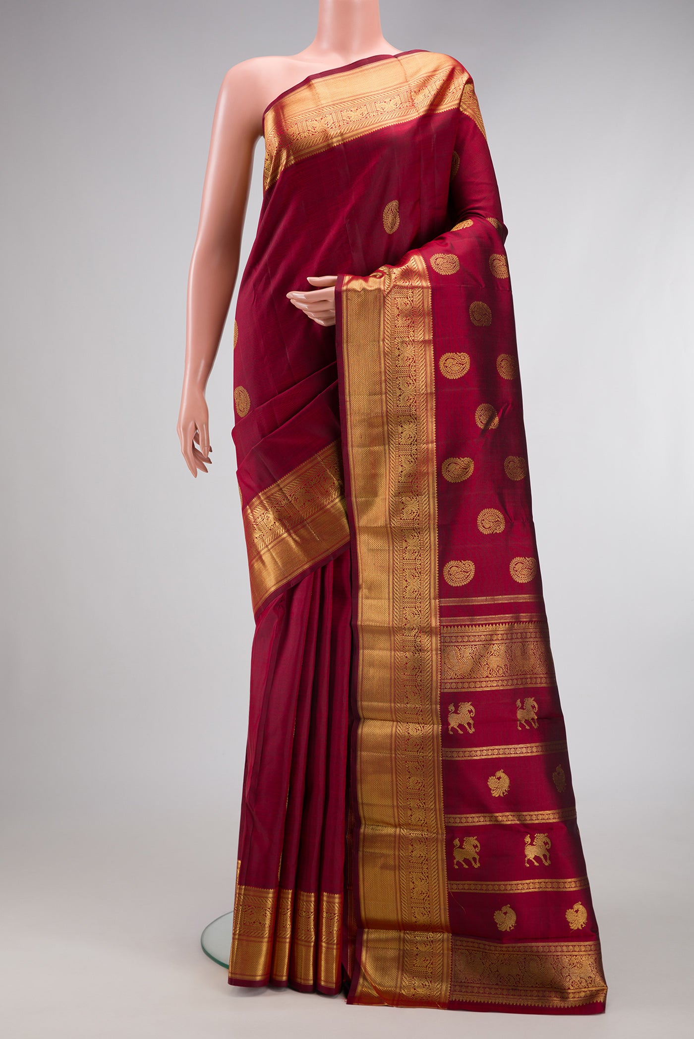Pure Silk Pure Zari Maroon Kanjivaram Saree with Zari Butta on the body and Zari Border.  displayed on a mannequin