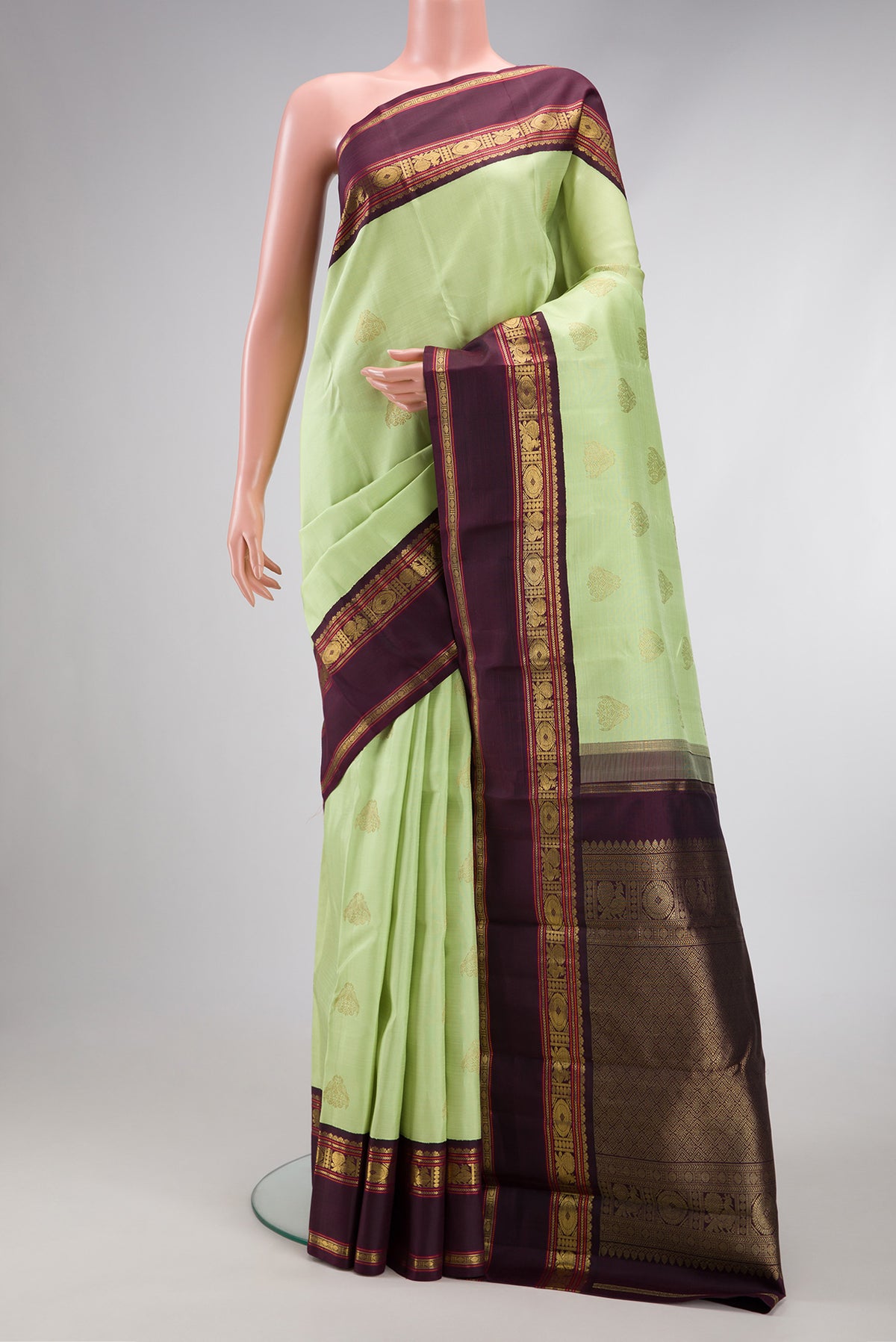 Pure Silk Pure Zari Parrot Green Dual Tone Kanjivaram Saree with Zari Butta on the body and Zari Border.  displayed on a mannequin
