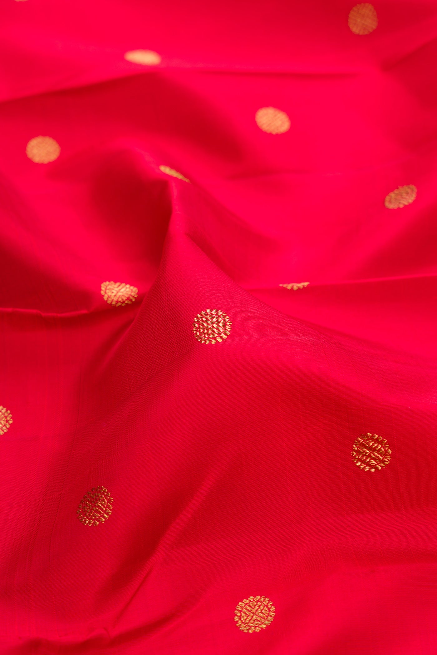 Close up of Pure Silk Pure Zari Red Kanjivaram Saree with Zari Butta on the body and Ganga Jamuna Border.  displaying folds