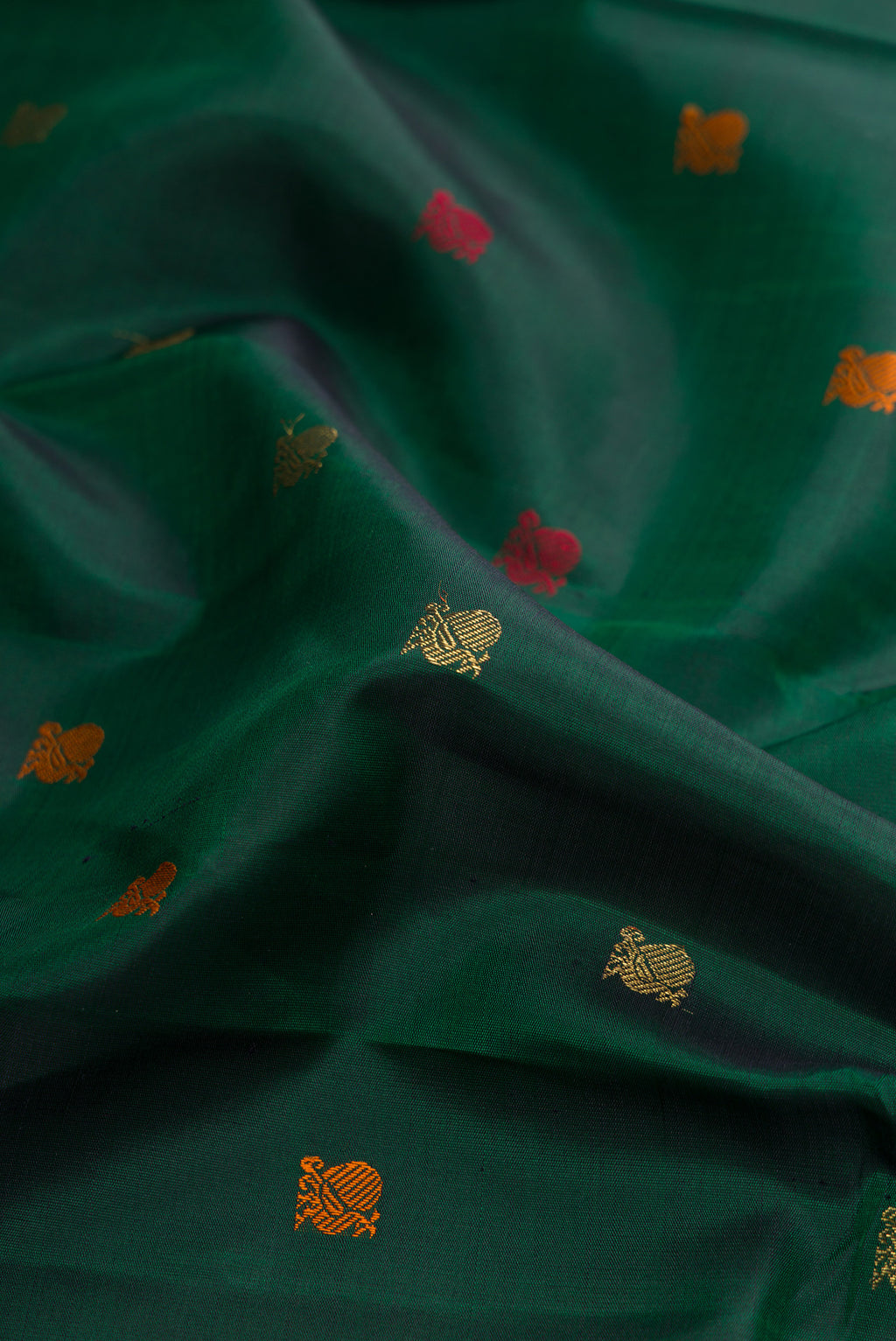 Close up of Pure Silk Pure Zari Bottle Green Dual Tone Kanchipuram Saree with Zari And Thread Butta on the body and Zari Border.  displaying folds