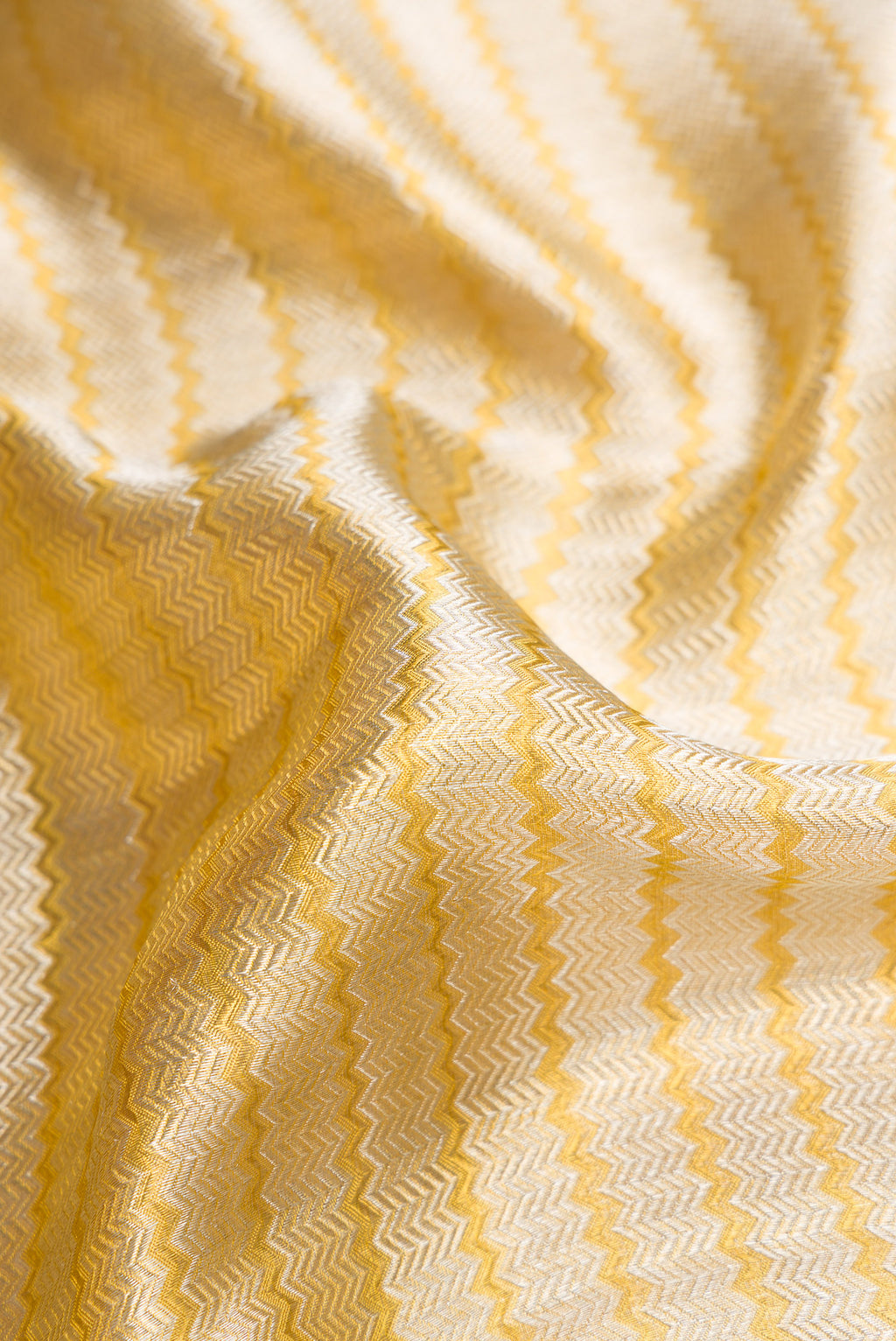 Close up of Silver Dual Tone Kanjivaram Tissue Silk Saree with Zari Brocade on the body and Zari Border.  displaying folds