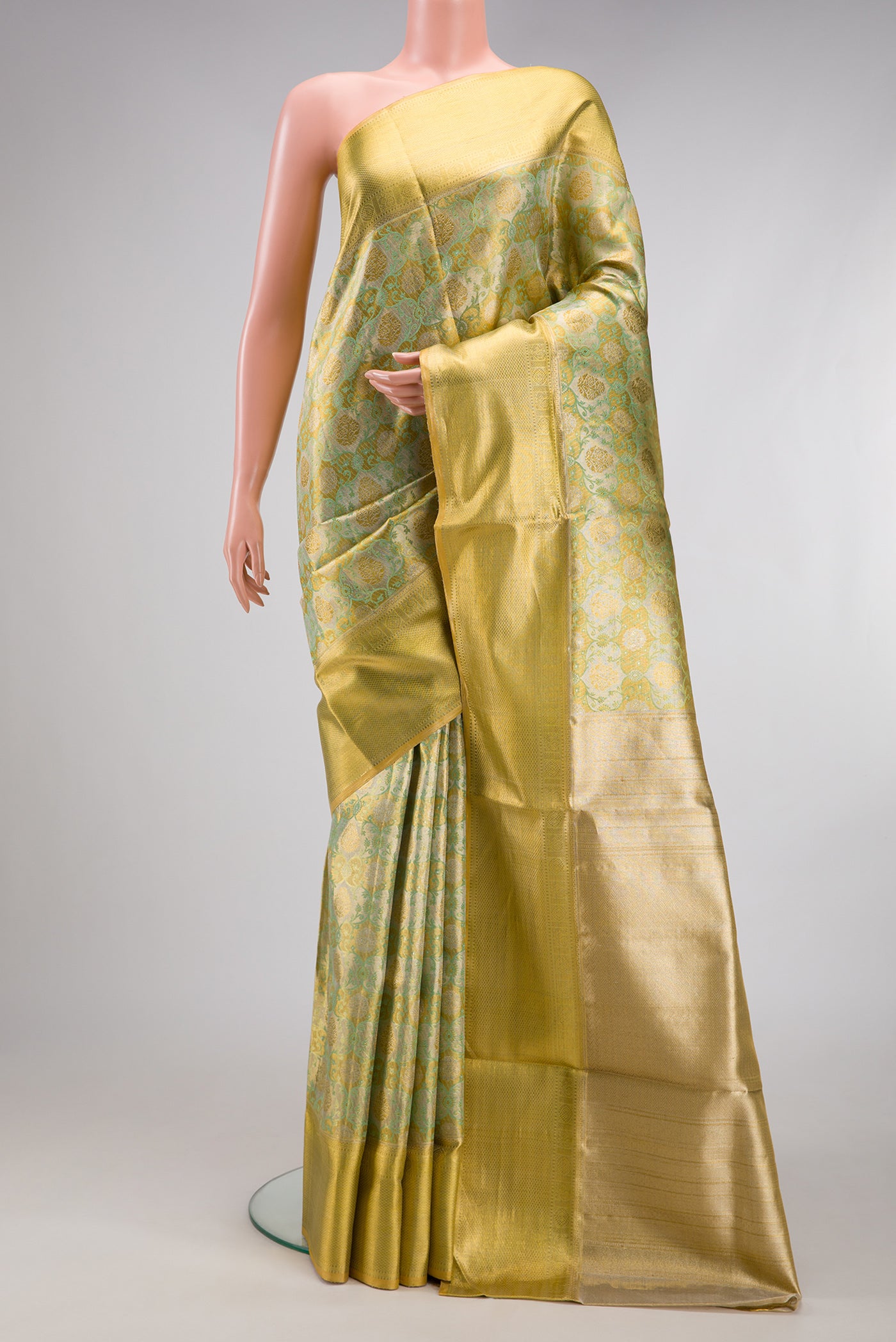 Pista Green Dual Tone Kanjivaram Tissue Silk Saree with Zari Brocade on the body and Zari Border.  displayed on a mannequin
